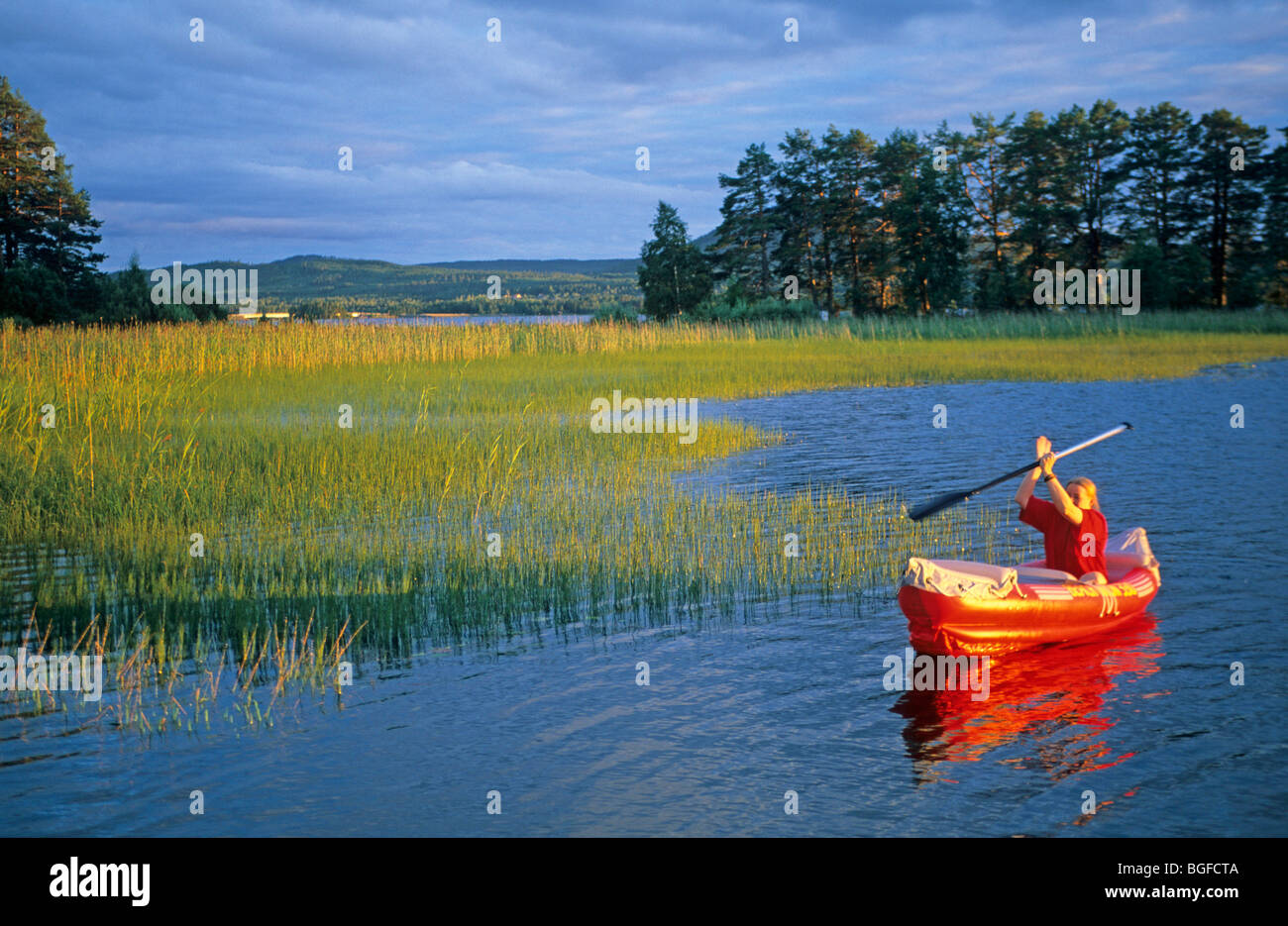 Giovane donna in un gommone, sul lago Siljan vicino Utanmyra, Svezia centrale Foto Stock