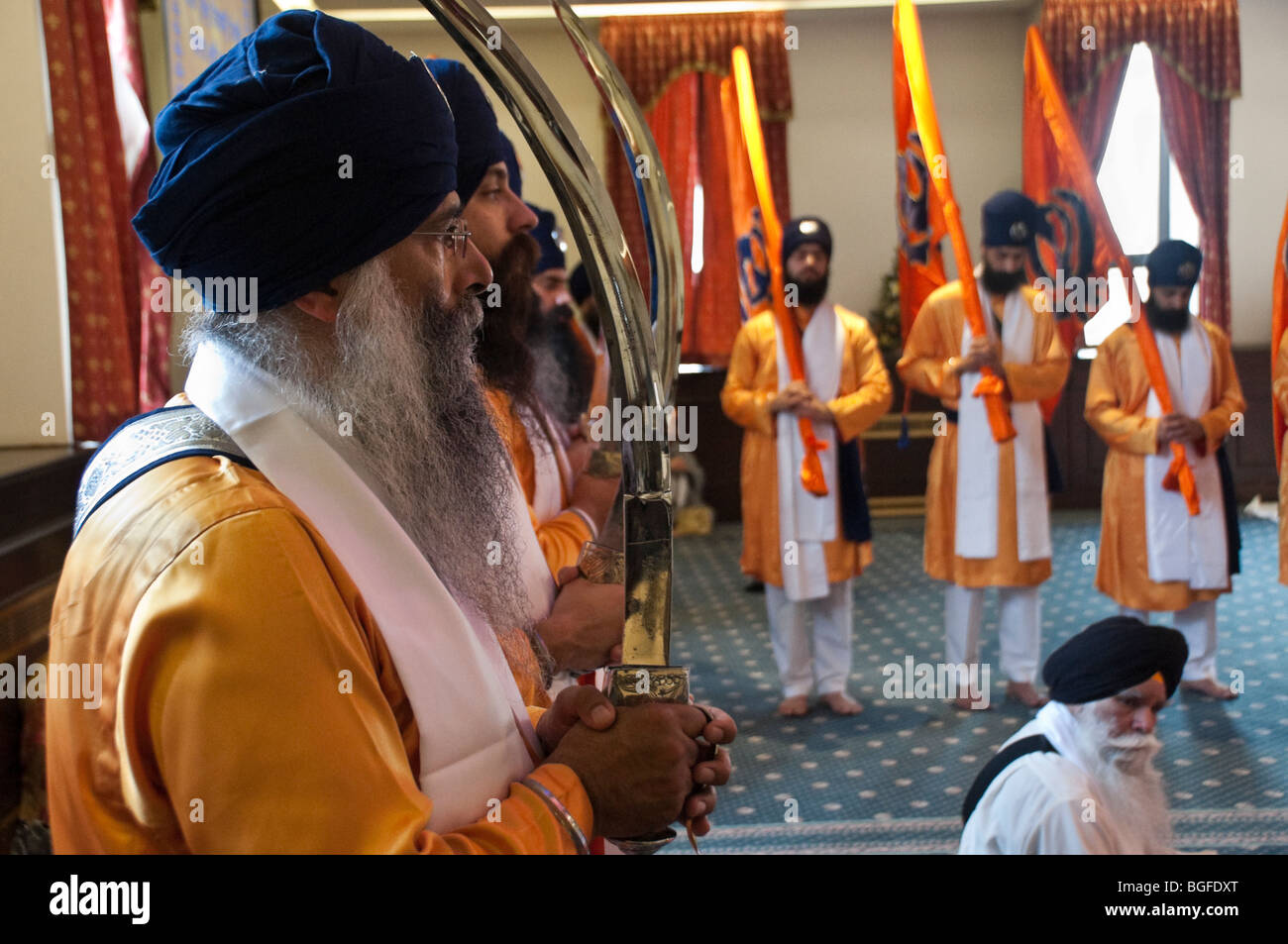 Diwan hall: Panj Piyare e Khalsa con Nisan Sahib (flag) di sostare dietro il Guru Granth Sahib durante le celebrazioni Vaisakhi Foto Stock