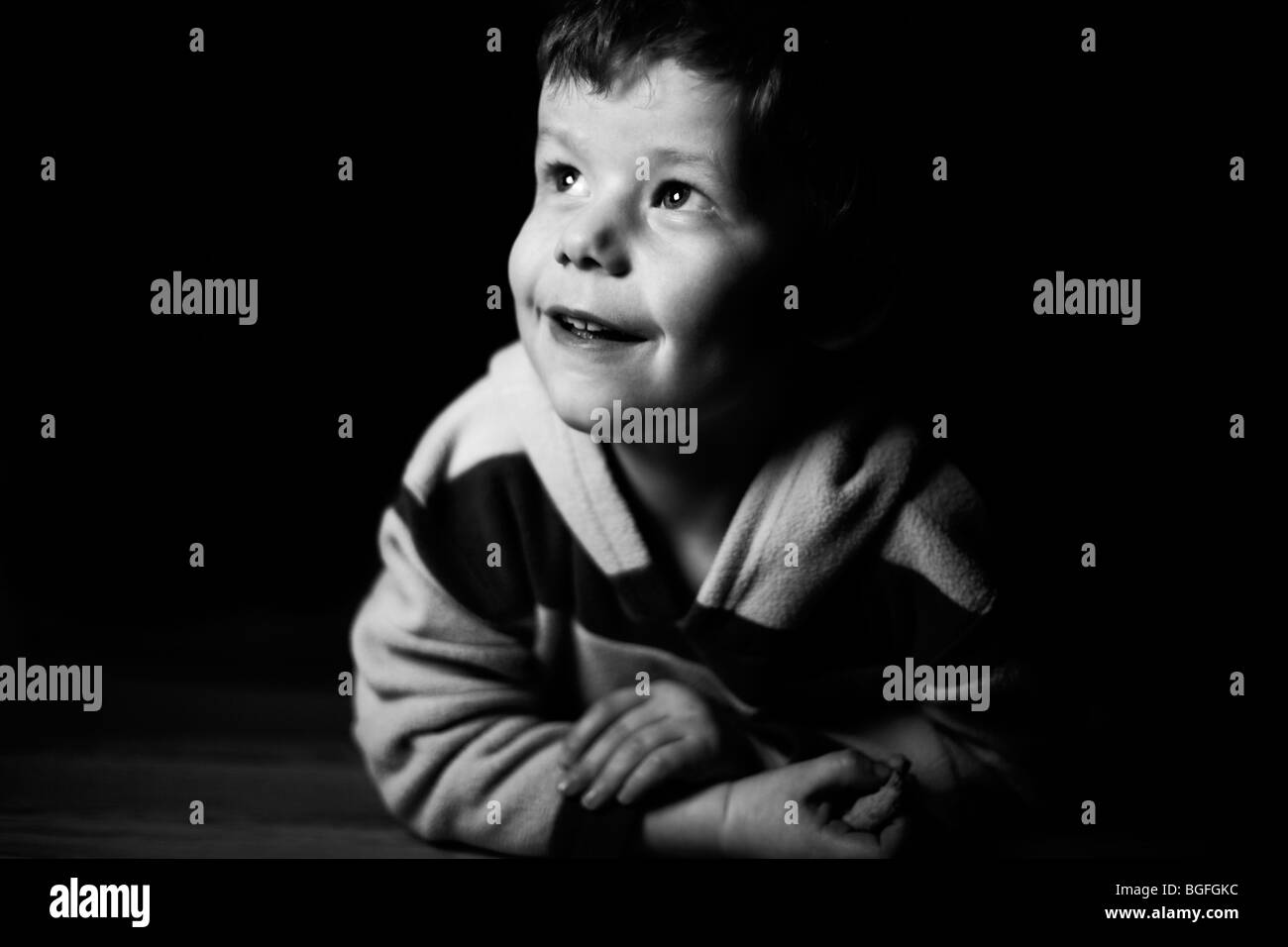 Foto in bianco e nero di un 5 anno vecchio ragazzo in illuminazione drammatica Foto Stock