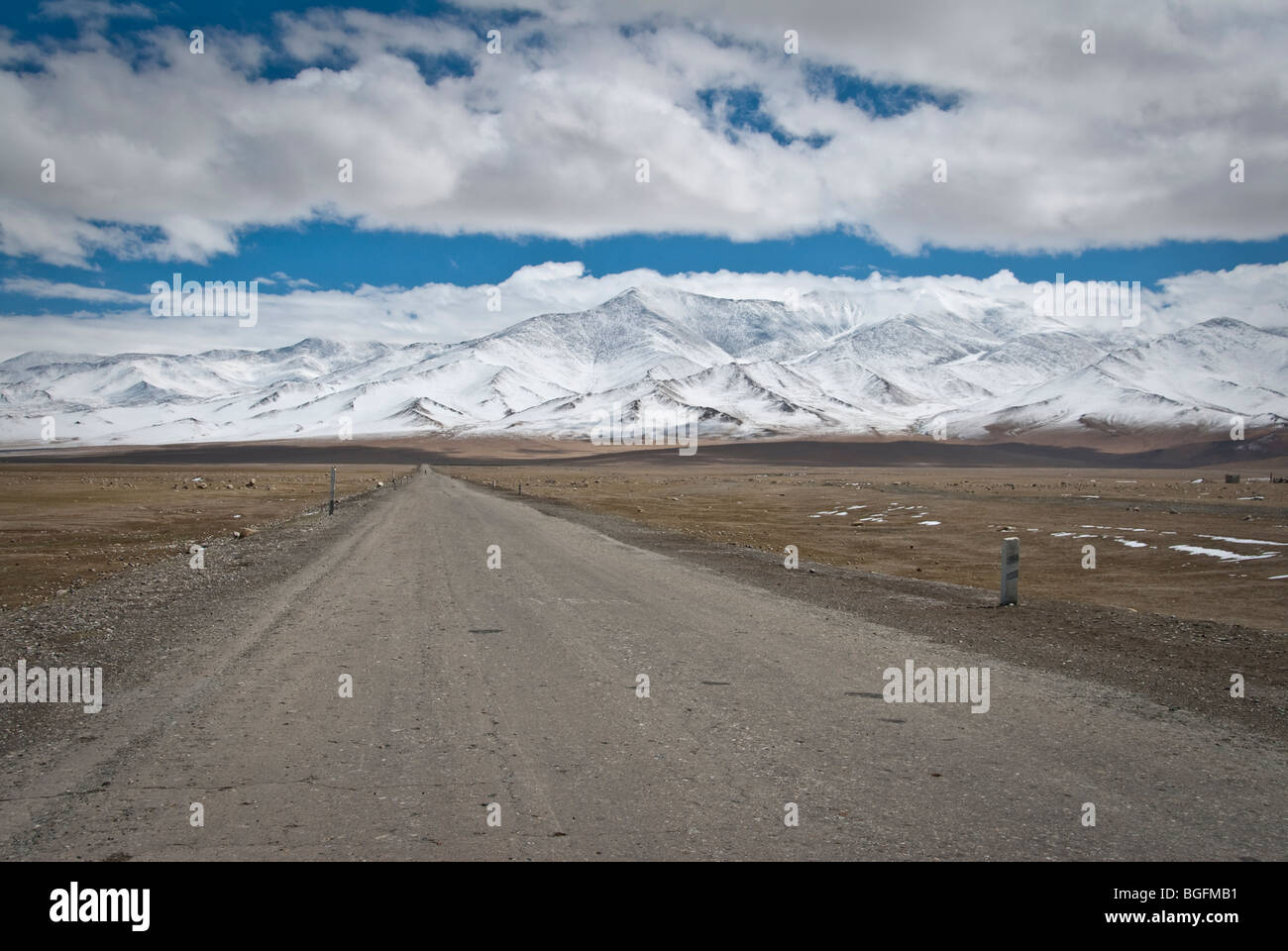 Vista della strada principale di Karakul con montagne innevate sullo sfondo, Tagikistan. Foto Stock
