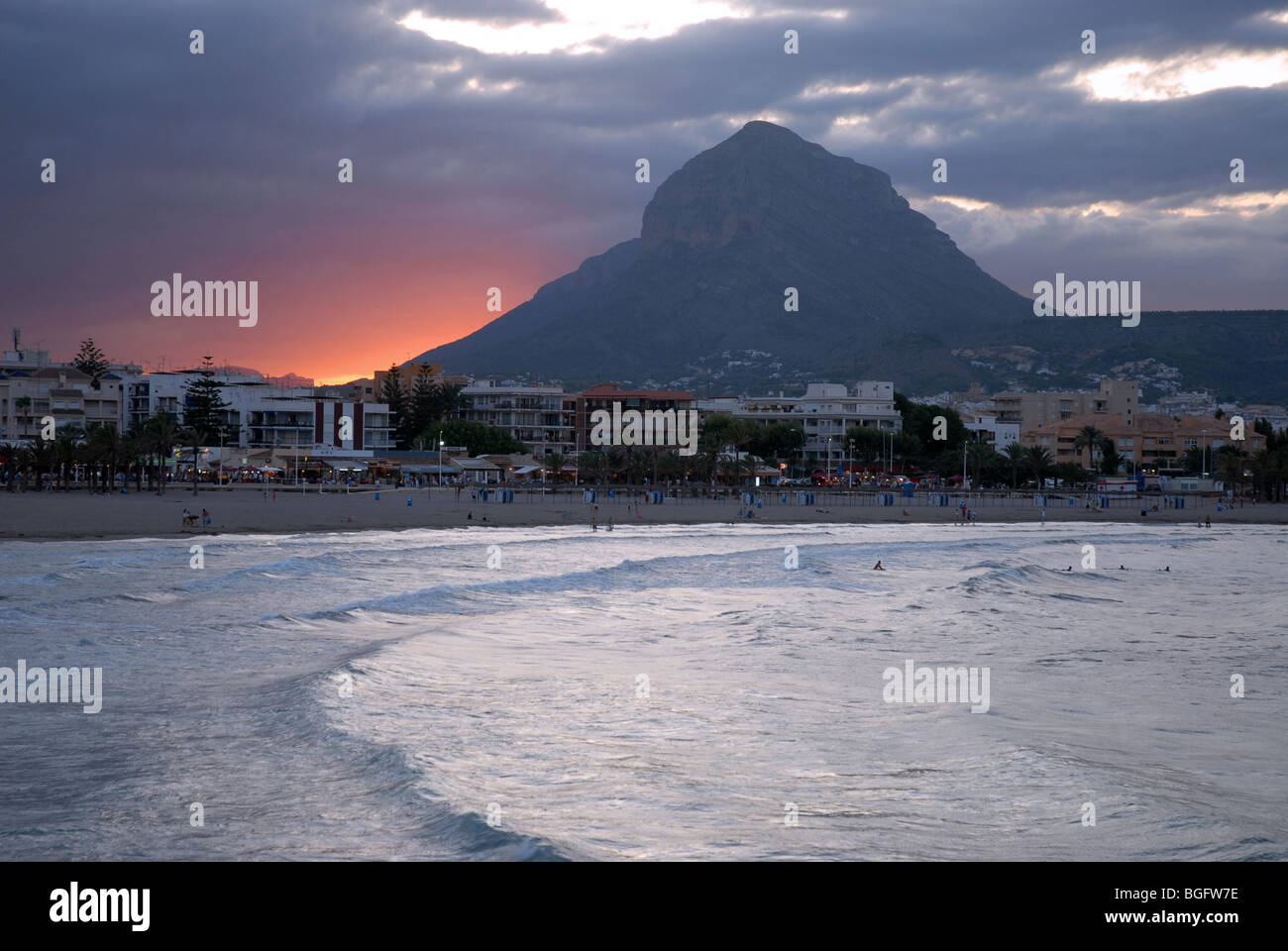 Vista della spiaggia di Arenal area con tramonto dietro Montgo, Javea / Xabia, Provincia di Alicante, Comunidad Valenciana, Spagna Foto Stock