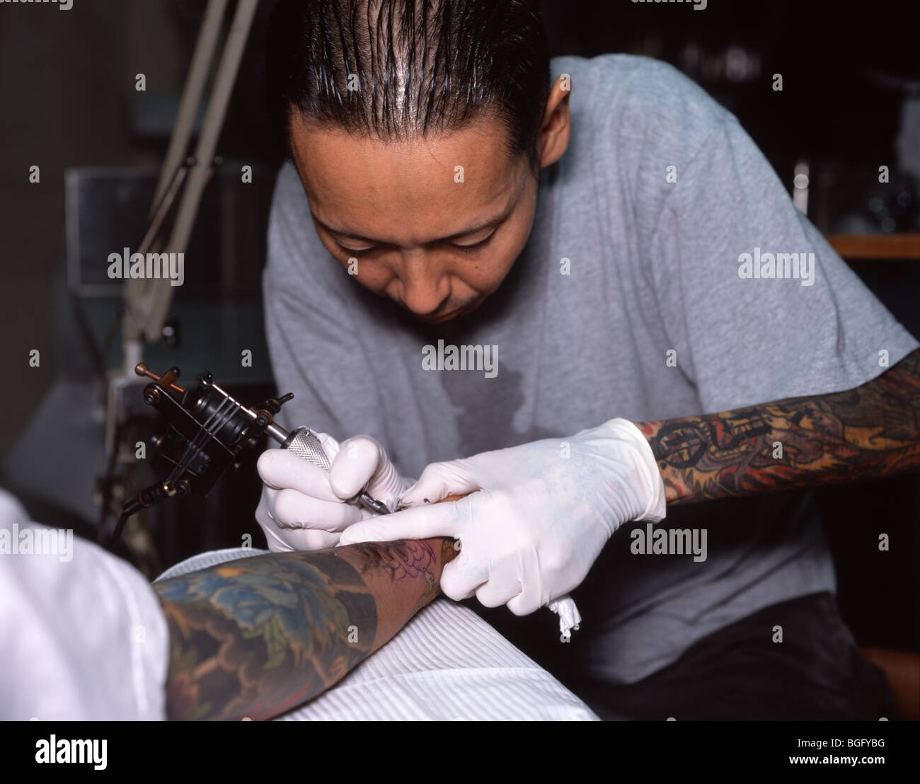 Tatuaggio giapponese artista che lavora su irezumi tradizionale sul braccio di client. Foto Stock