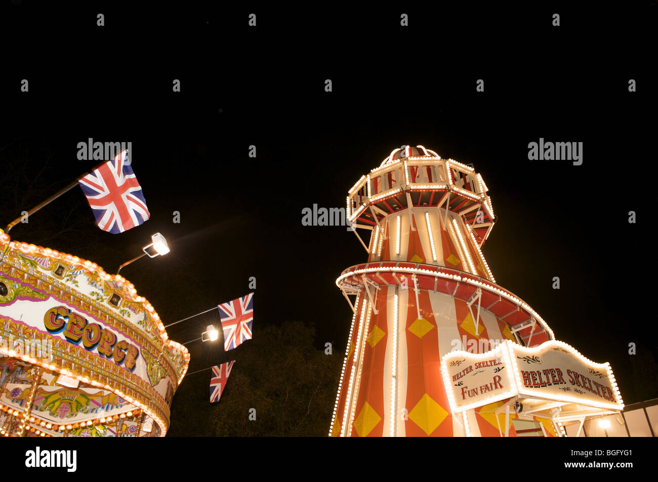 Helter Skelter e giostra in una fiera Foto Stock