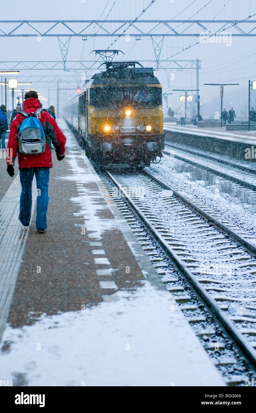 Pendolari combattendo attraverso la neve a prendere un treno a Amsterdam Zuid stazione ferroviaria nei Paesi Bassi Foto Stock