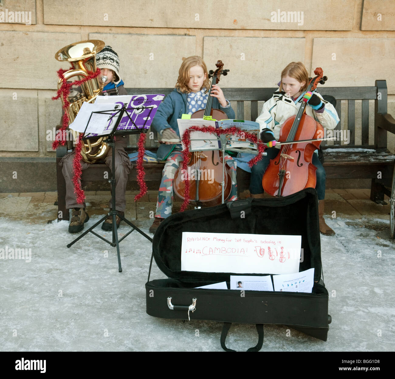 Giovane musicista di strada bambini per le strade di Cambridge per il supporto di terzo mondo istruzione in Cambogia, la piazza del mercato, Cambridge Regno Unito Foto Stock