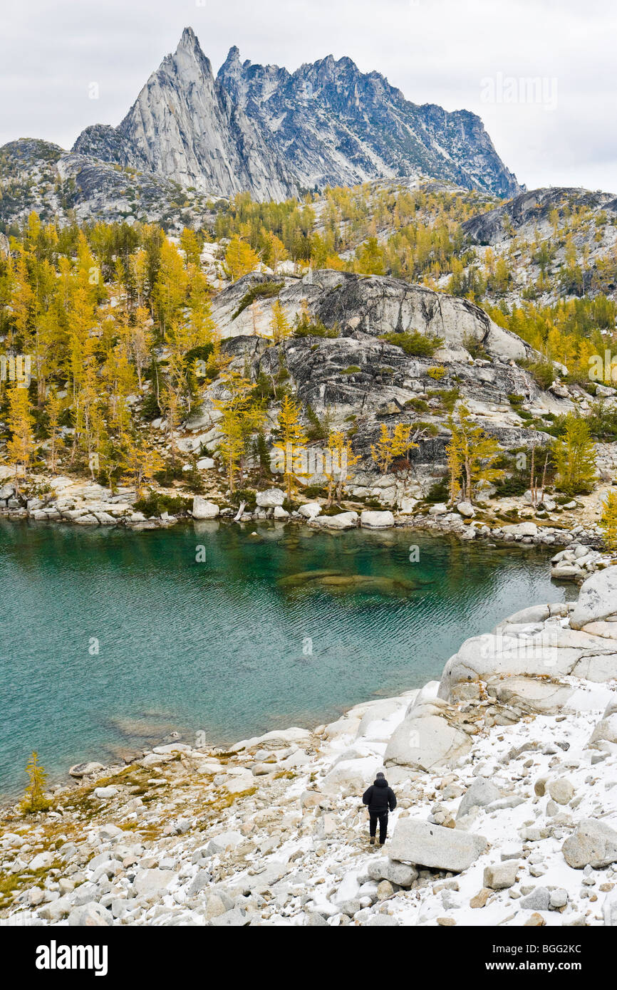 La vista di una donna scende da un astragalo campo verso il lago di ispirazione con picco Prusik a distanza, un incantesimo Laghi Foto Stock