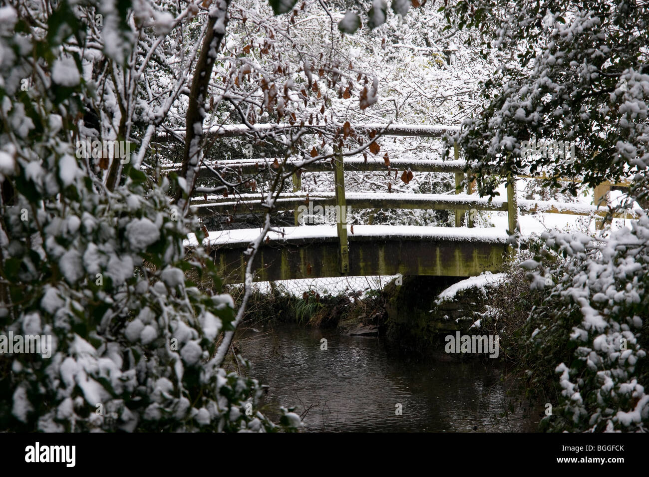 La neve si stabilì su un piccolo ponte pedonale. Lacock Wiltshire Inghilterra Regno Unito Foto Stock