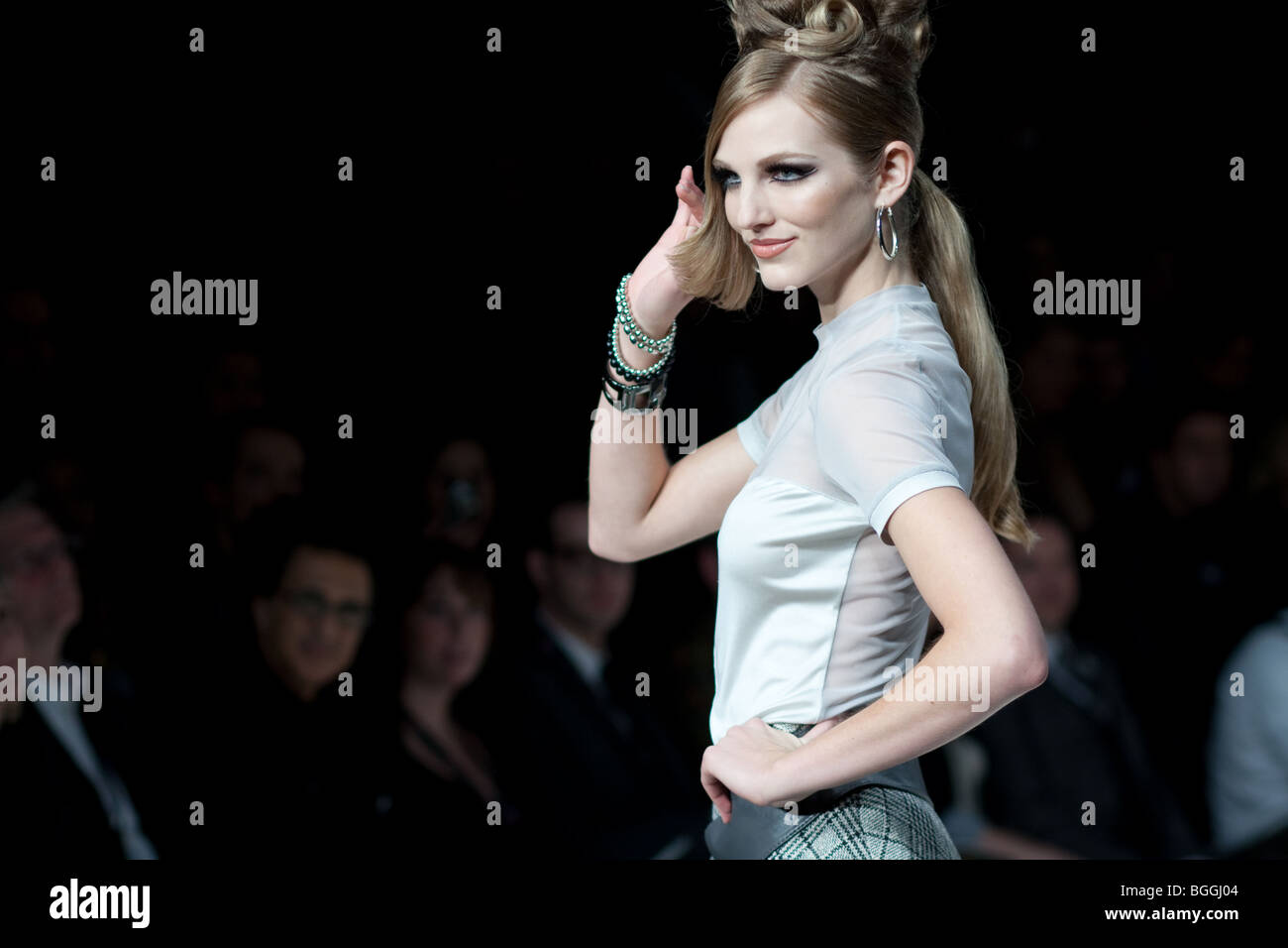 I modelli femminili che indossa la moda progetta camminando sulla pista con un overflow del pubblico al Toronto LG fashion week Foto Stock