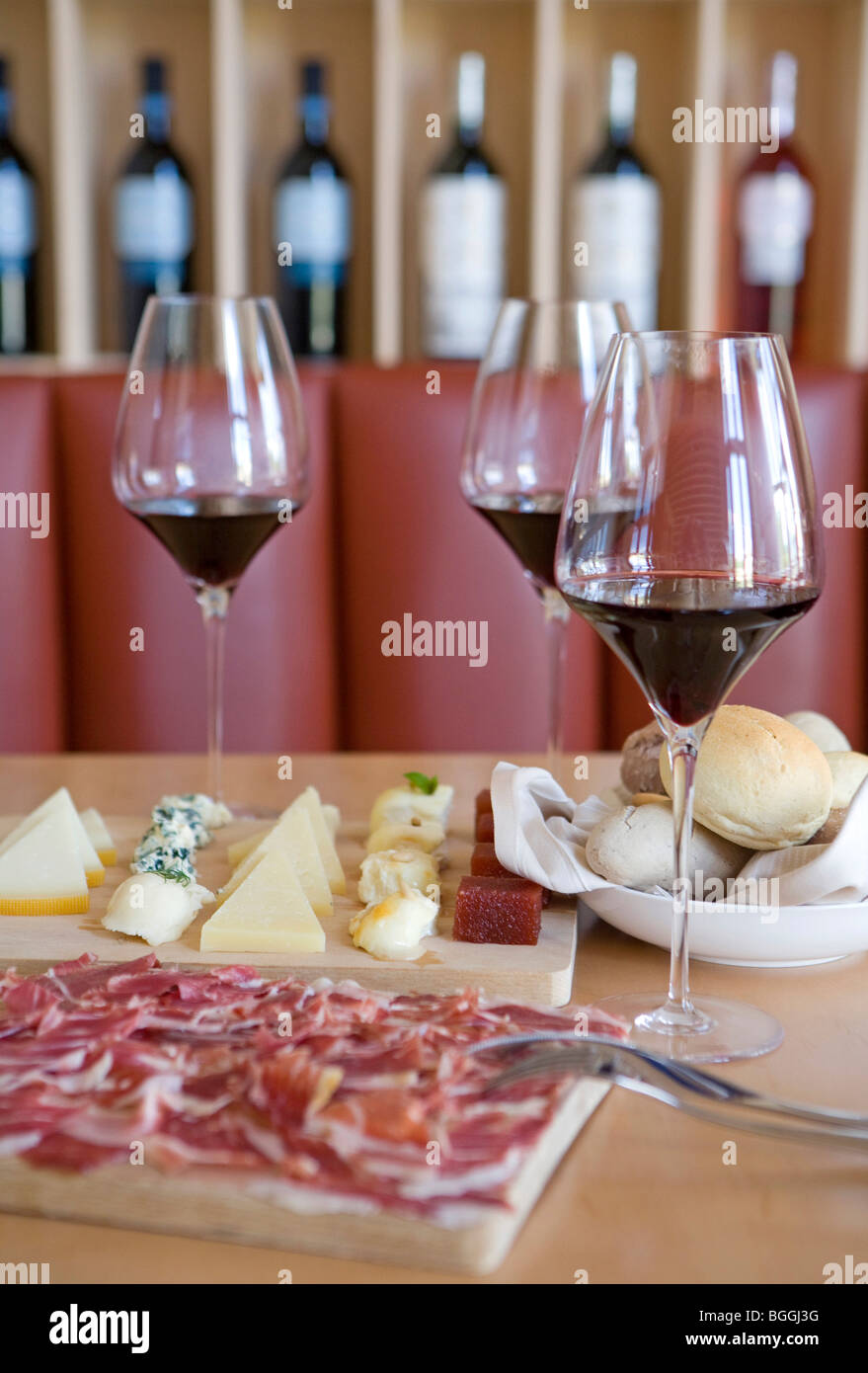 Bicchieri di vino, formaggio, prosciutto e panini su un tavolo, Elciego, Spagna Foto Stock