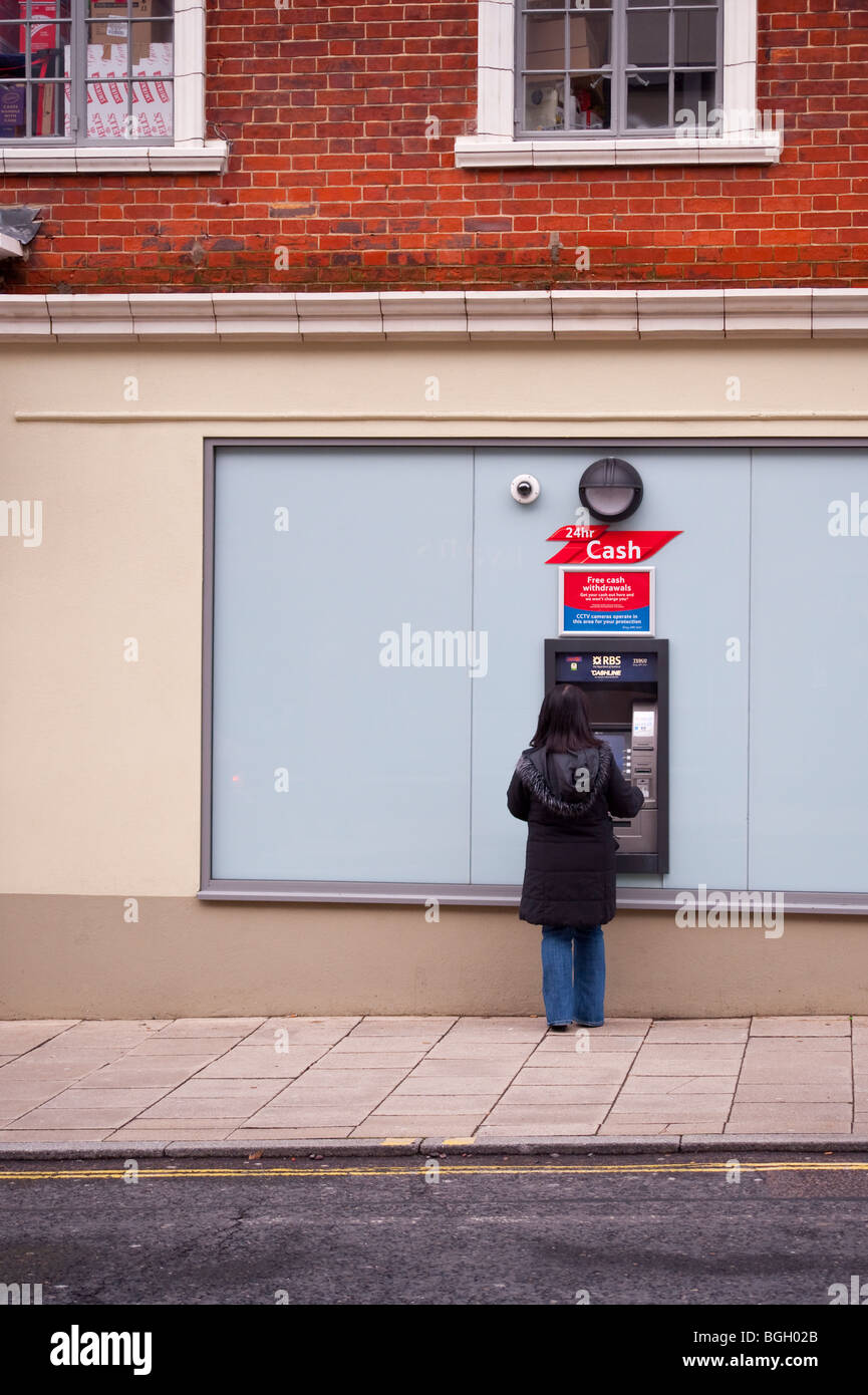 Una donna riceve denaro contante dai bancomat speedbank macchina in Norwich, Norfolk, Regno Unito Foto Stock