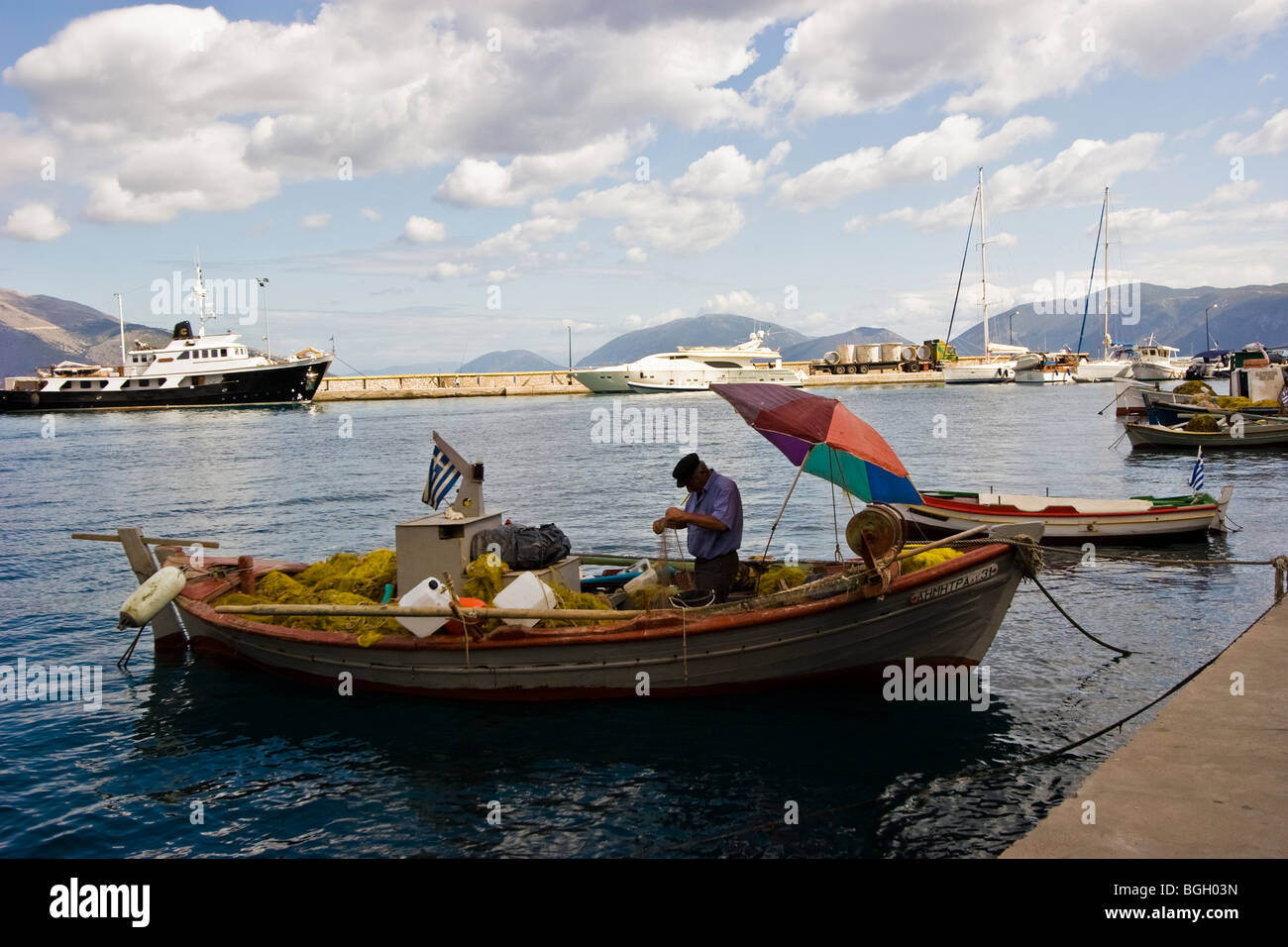 Un vecchio pescatore greco si prepara per i giorni di pesca e fissa la sua rete da pesca. Sami, Cefalonia, Grecia Foto Stock