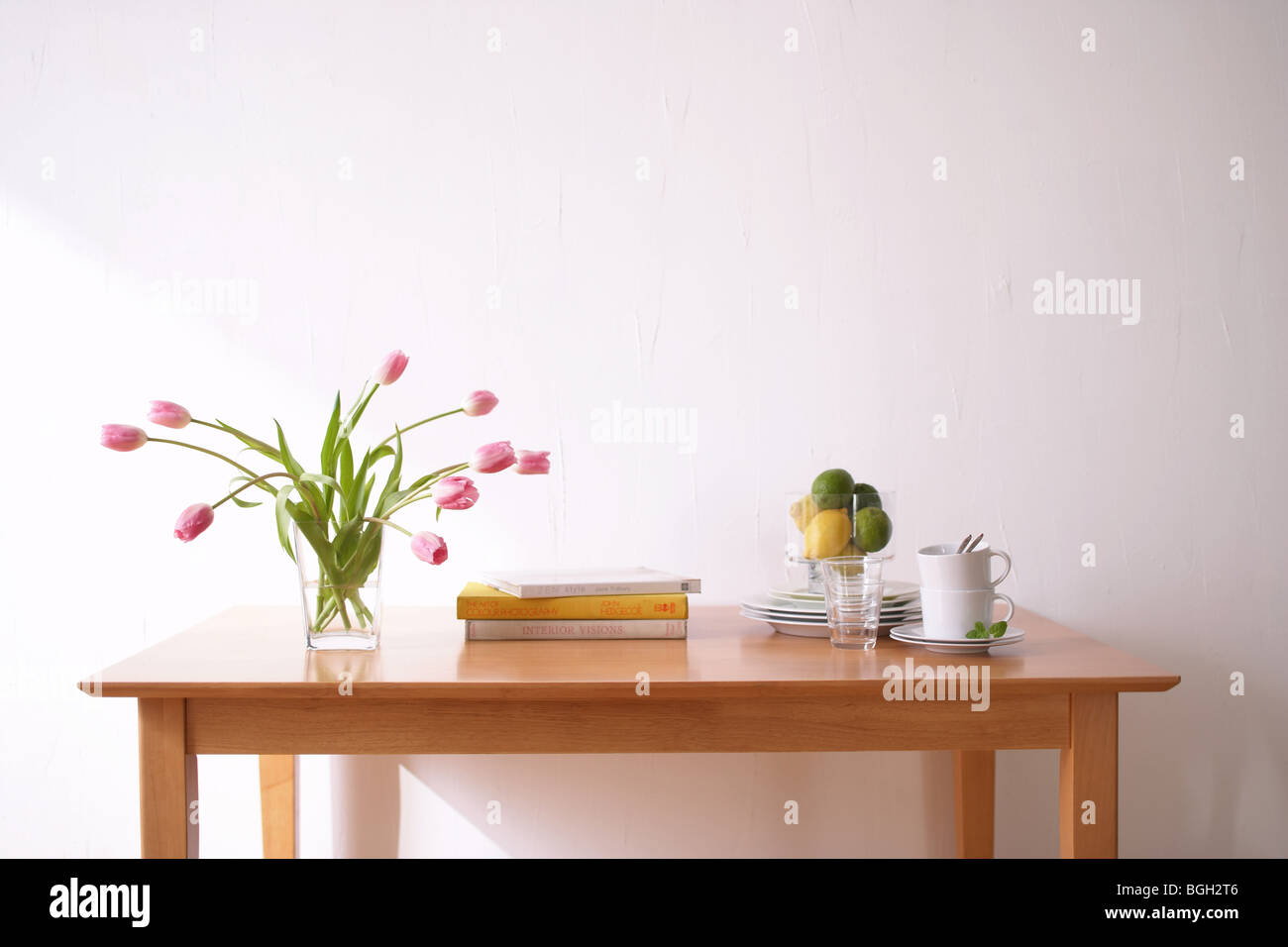 Tavolo con stoviglie e tulipani rosa in vaso Foto Stock