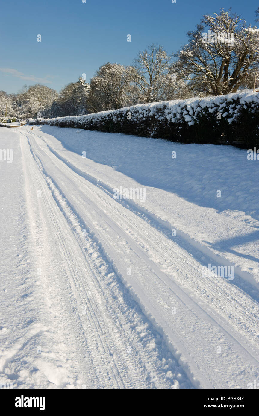 Tracce di pneumatici nella neve appena dopo una nevicata invernale in Chilterns campagna vicino a Chalfont St Giles Buckinghamshire REGNO UNITO Foto Stock