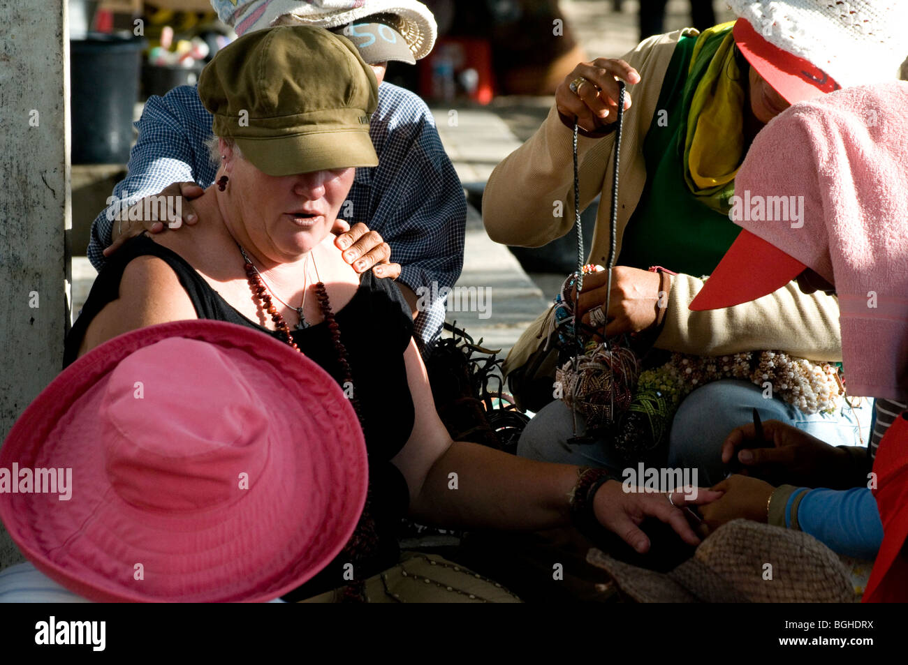 Turista bersagliata dai venditori ambulanti e massaggiatori, Kuta Beach, Bali, Indonesia Foto Stock
