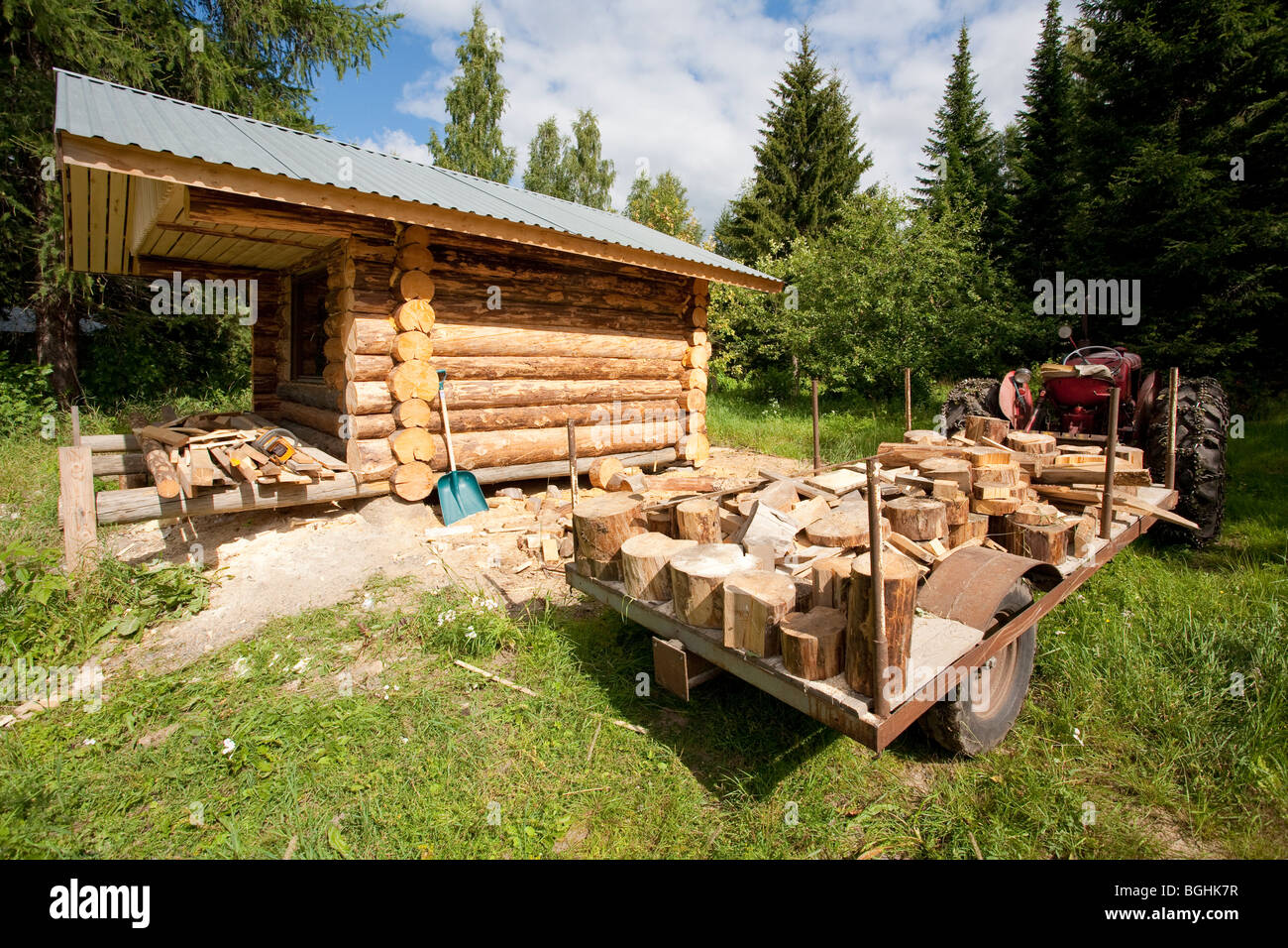 Il trattore rimorchio pieno di blocchi di legno che sono avanzi di log cabin costruzione , Finlandia Foto Stock