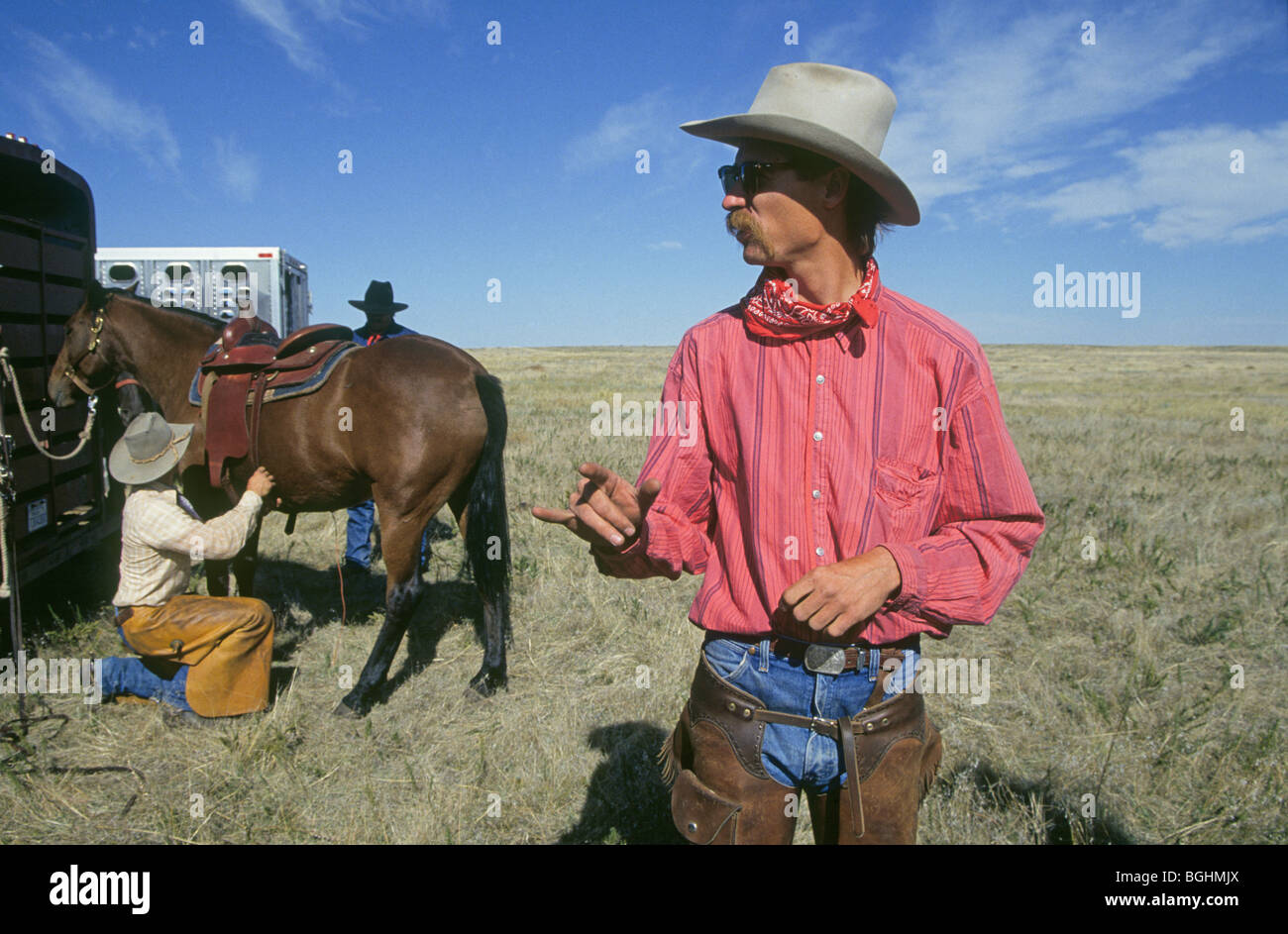 Cowboy e i loro cavalli si prepara ad affrontare un viaggio a cavallo nel Parco nazionale Badlands, Dakota del Sud Foto Stock