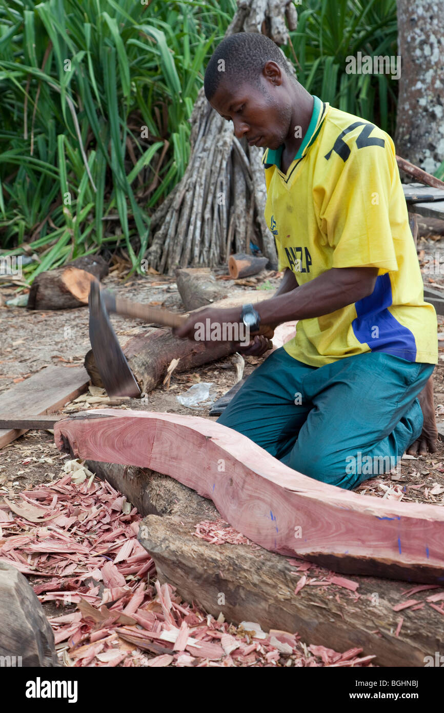 Il Ras Nungwi, Zanzibar, Tanzania. Costruzione di un dhow. La sagomatura di una nervatura interna del supporto con un'ascia. Foto Stock