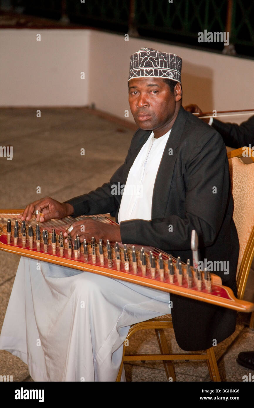 Zanzibar, Tanzania. Taarab musicisti. Cultura Club musicali. Qanun Player, indossando un tradizionale Zanzibari hat, kofia. Foto Stock