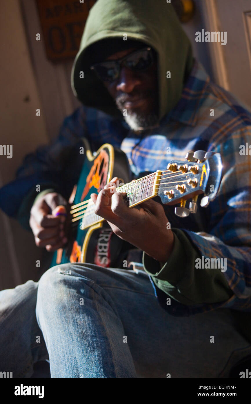 Musicista di strada suonando la chitarra su un marciapiede nel Quartiere Francese di New Orleans, Lousiana Foto Stock