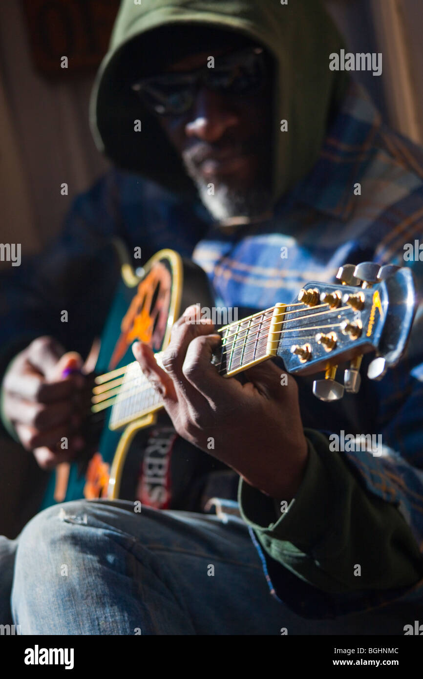 Musicista di strada suonando la chitarra su un marciapiede nel Quartiere Francese di New Orleans, Lousiana Foto Stock