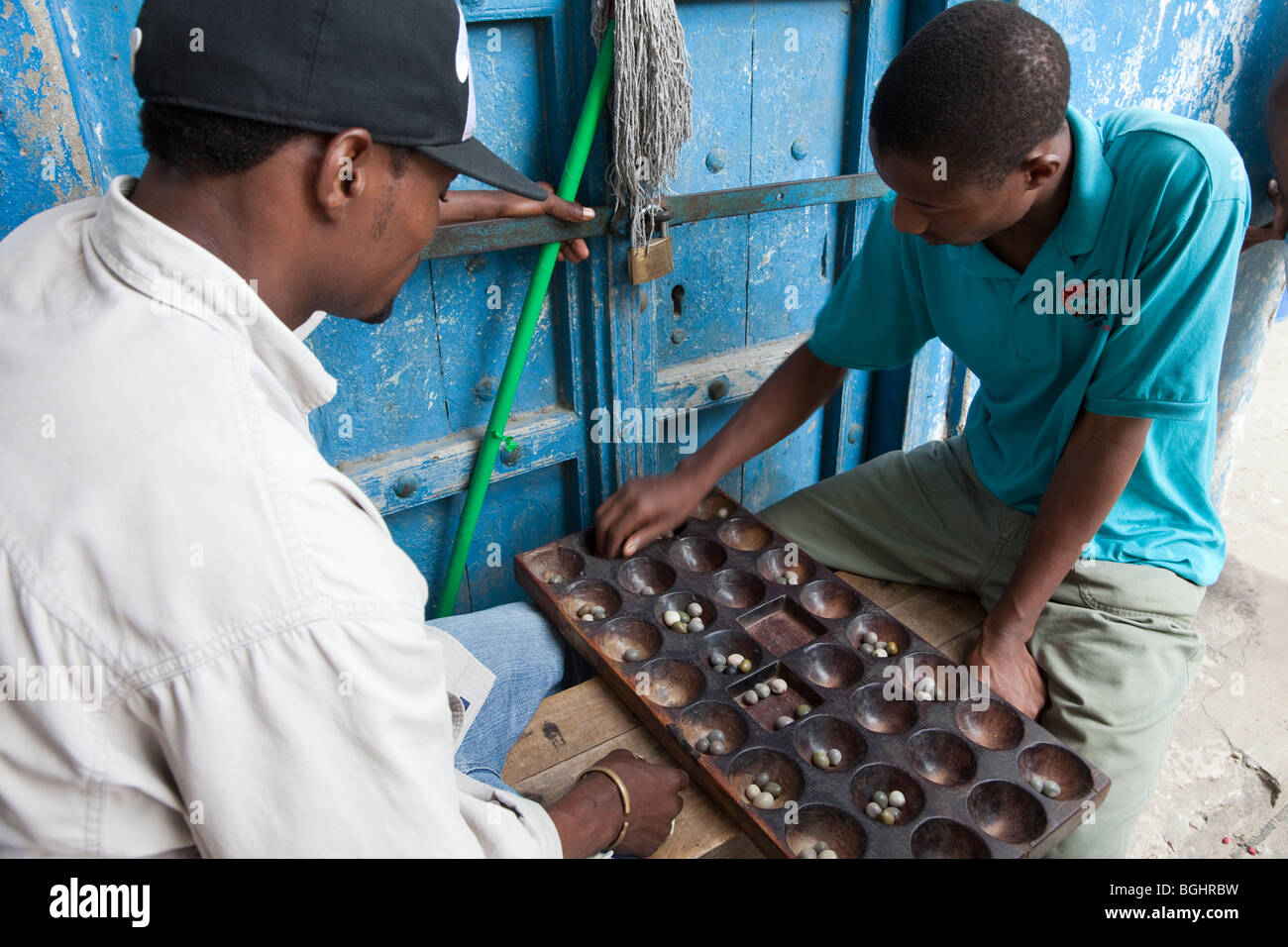 Zanzibar, Tanzania. Gli uomini che giocano Bao, un tradizionale gioco di africani. Foto Stock