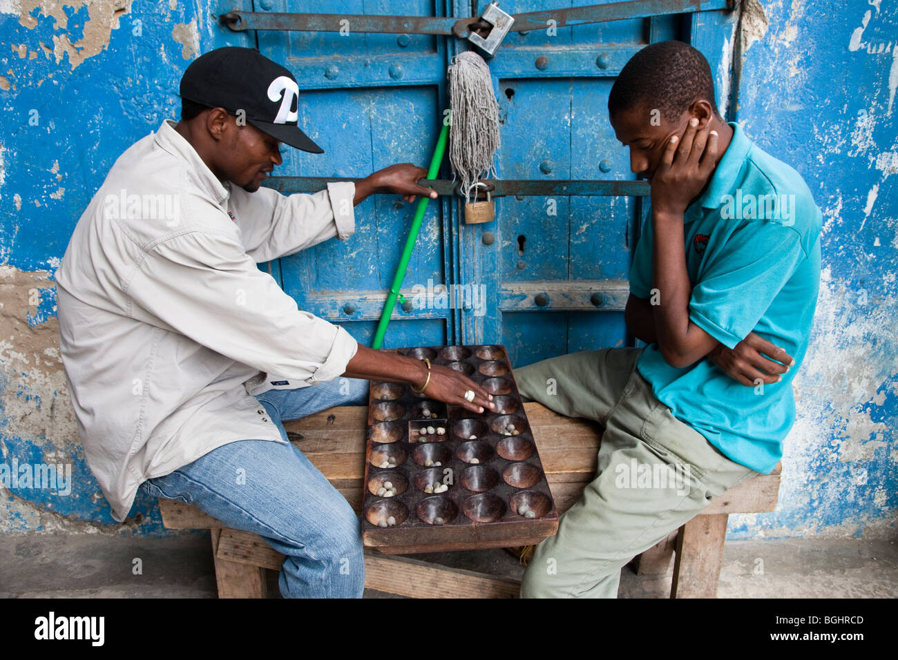 Zanzibar, Tanzania. Gli uomini che giocano Bao, un tradizionale gioco di africani. Foto Stock