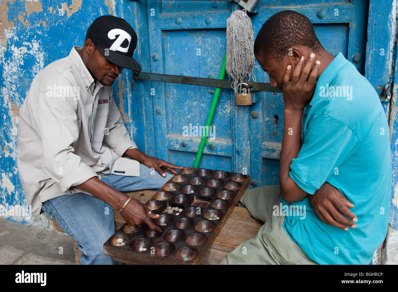 Zanzibar, Tanzania. Gli uomini che giocano Bao, un tradizionale gioco di africani. Foto Stock