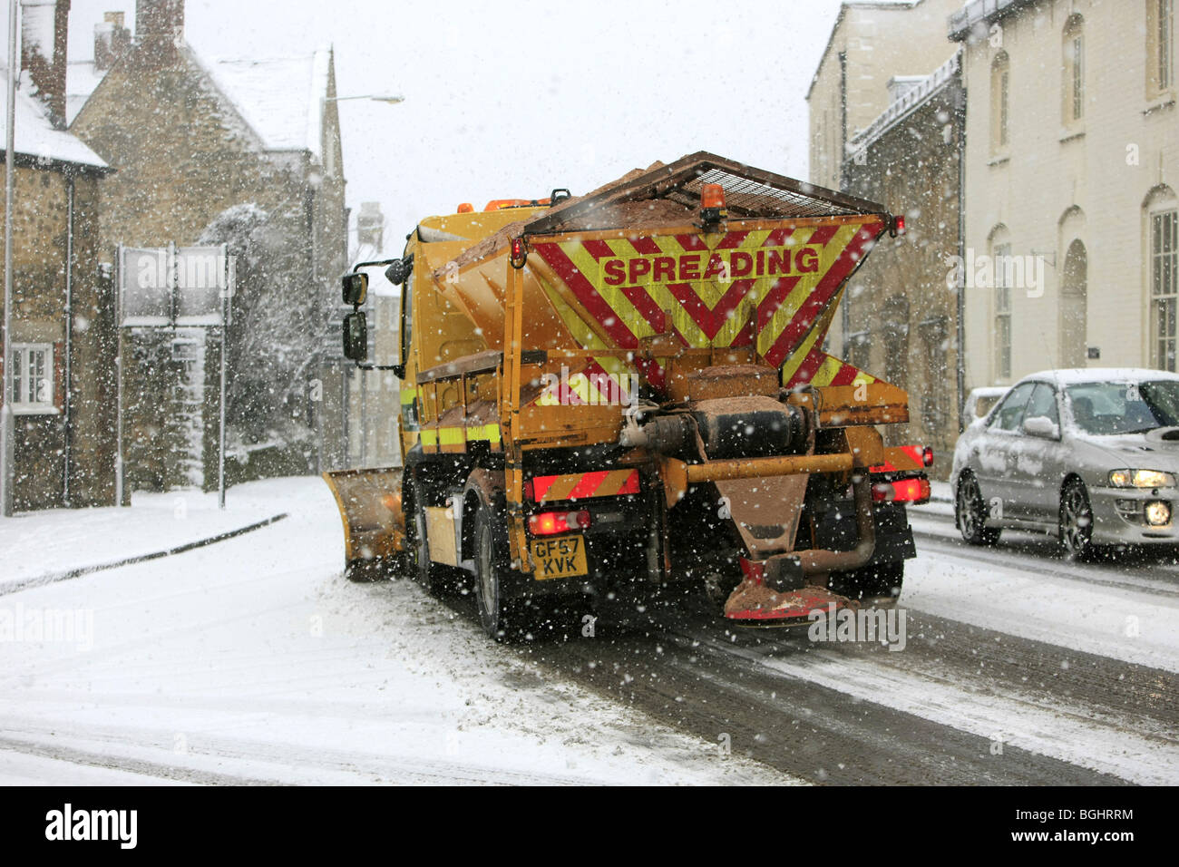 Un aratro di neve e gritter carrello a lavorare su una strada di Dorset durante una tempesta di neve Foto Stock