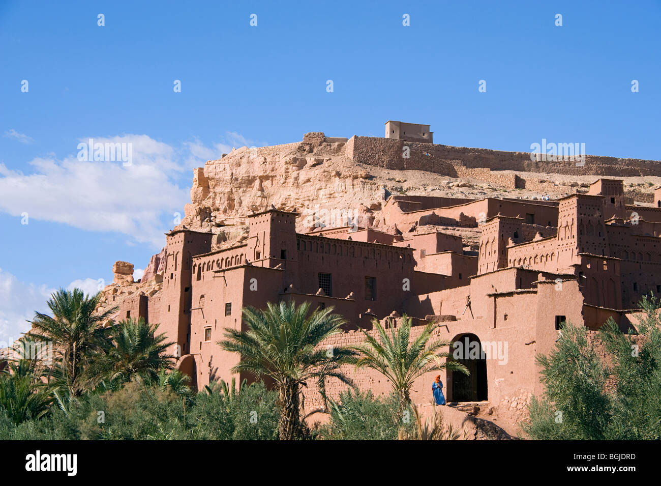 Uno scorcio di un uomo in costume locale, gandora blu e arancione shemagh ad Archway di Ait Ben Haddou Ksar in Marocco. Foto Stock