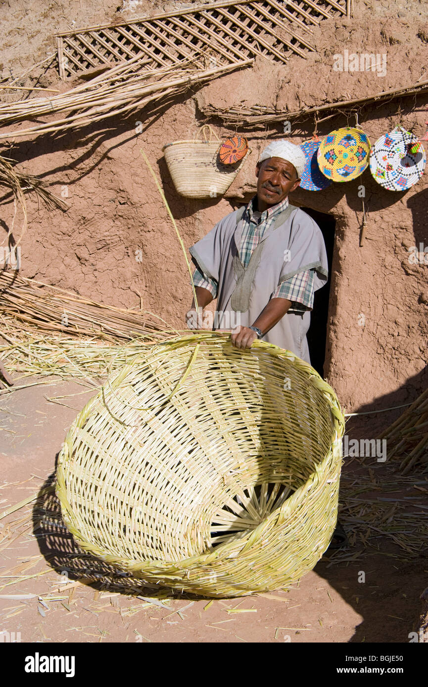 Un uomo berbera che mostra un gruppo di tour come egli si intreccia cesti a Ait Ben Haddou Ksar in Marocco. Foto Stock