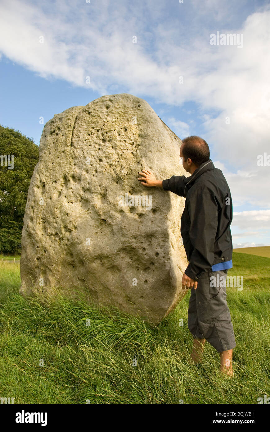 Uomo di toccare una pietra, cerchio di pietra, Avebury, Wiltshire, Inghilterra, Gran Bretagna, Europa Foto Stock