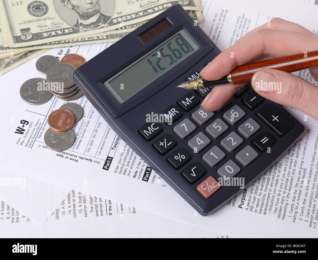 Femmina il calcolo manuale delle imposte su calcolatrice con W-9 imposta sul reddito sotto forma Foto Stock