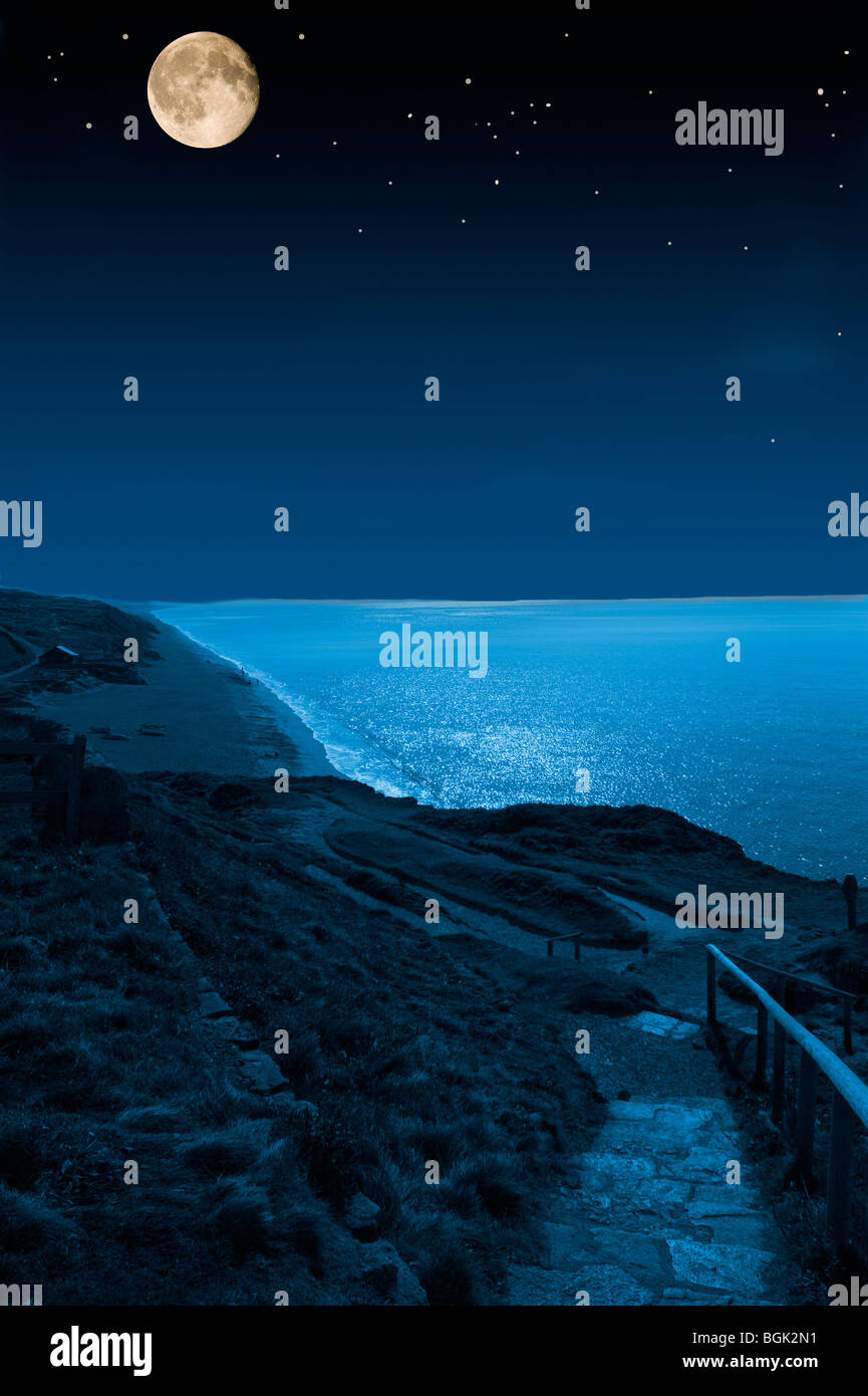 Un foto-montaggio del sud ovest via costiera nel Devon con un grande la luna e le stelle illuminazione del percorso e il mare. Foto Stock