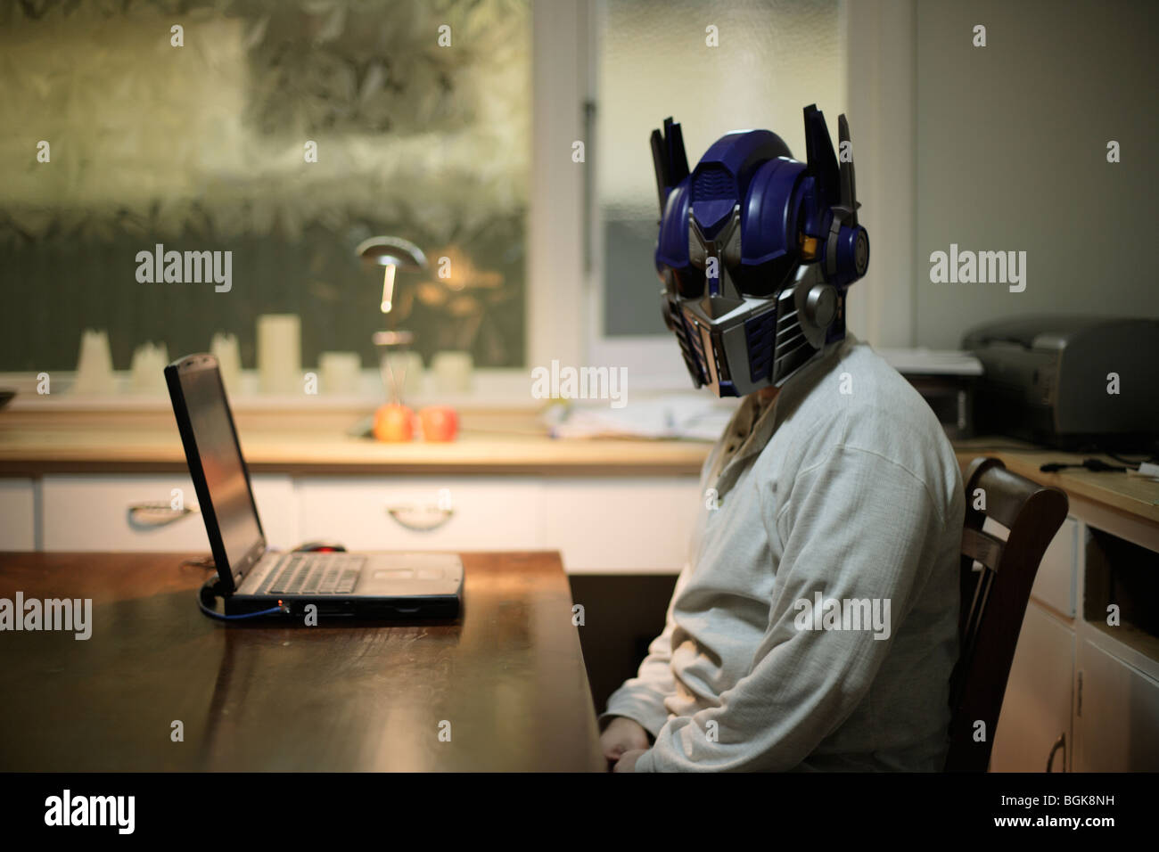 L uomo indossa il casco giocattolo del trasformatore robot Optimus Prime, un personaggio del film di Spielberg. Foto Stock