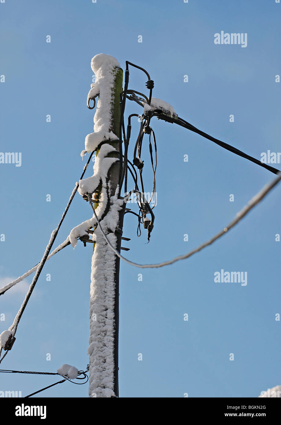 Potenza e un palo telefonico con la neve. Foto Stock