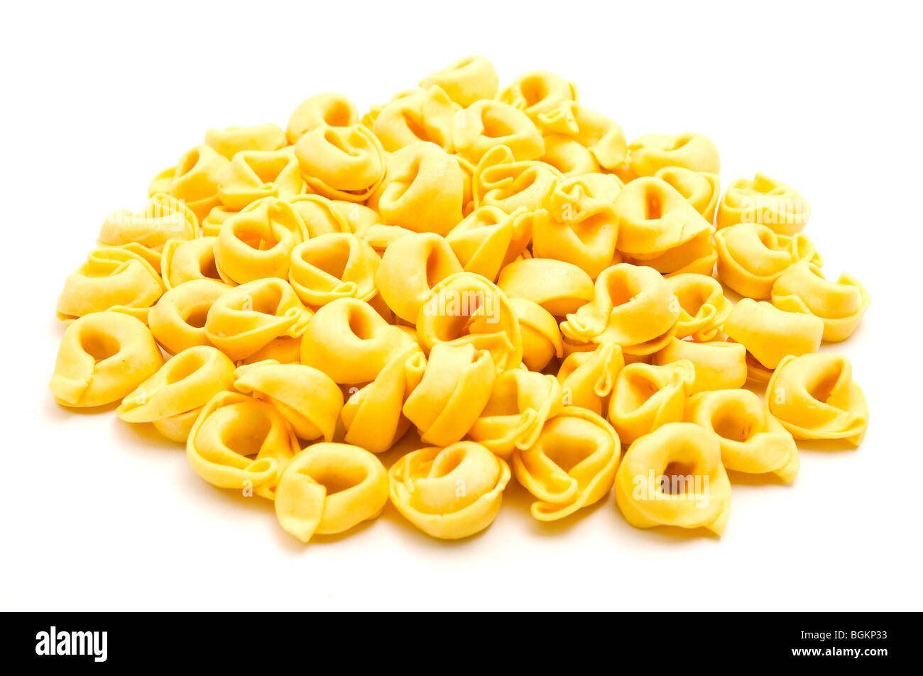 Tortellini (a forma di anello la pasta) su uno sfondo bianco Foto Stock