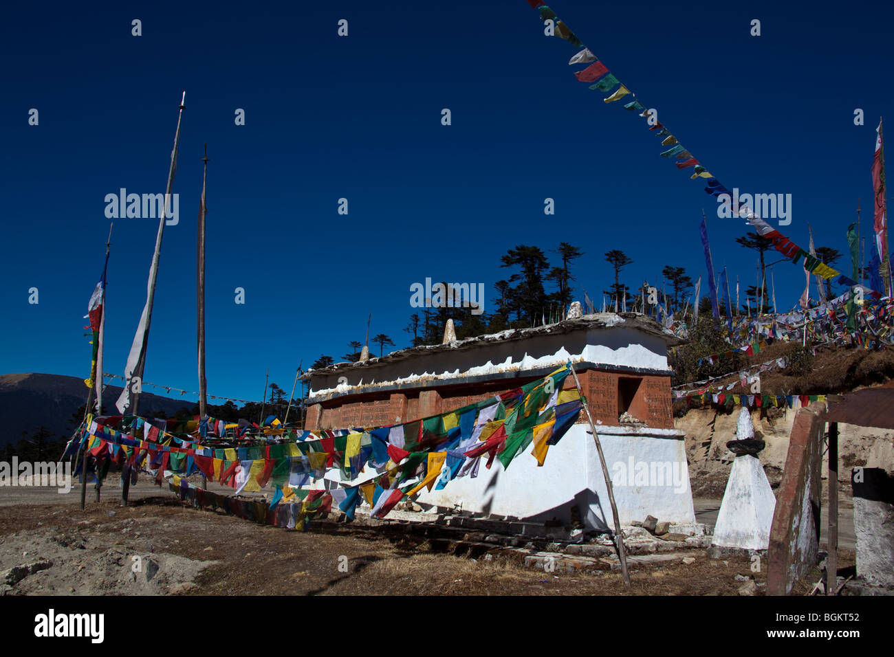 Bandiere di preghiera al Thrumshingla pass a 3800m segnando il divario tra occidente e oriente Bhutan Foto Stock