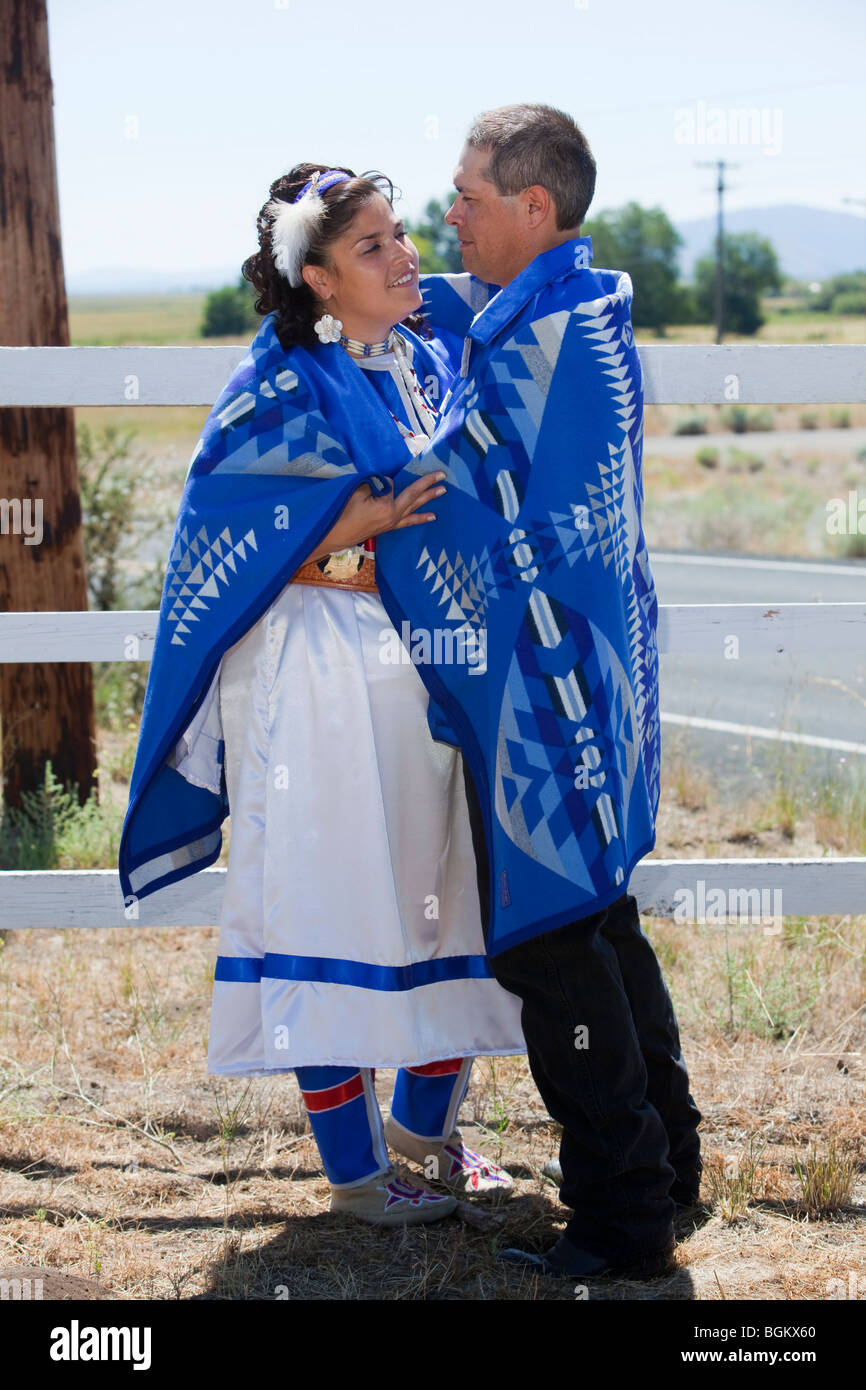 Coppie native americane vestite di abbigliamento tradizionale sono avvolte  insieme all'interno di una coperta indiana, simbolo di un lungo e felice  matrimonio Foto stock - Alamy