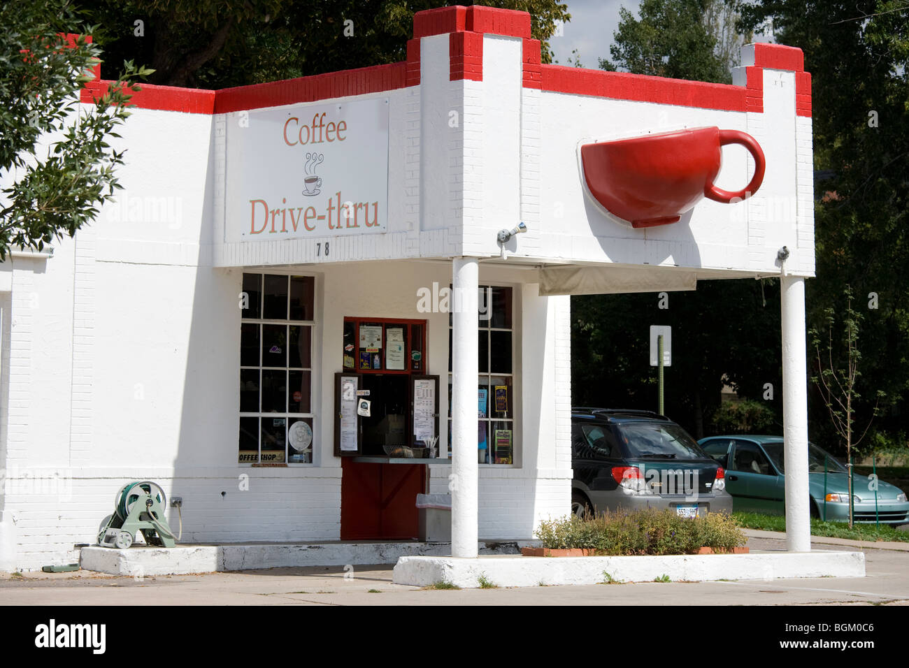 Denver in Colorado. Buzz Cafe in un convertito gas di riempimento della stazione di servizio ha un gigante rosso tazza da caffè mug sporgenti dalla parete. Foto Stock