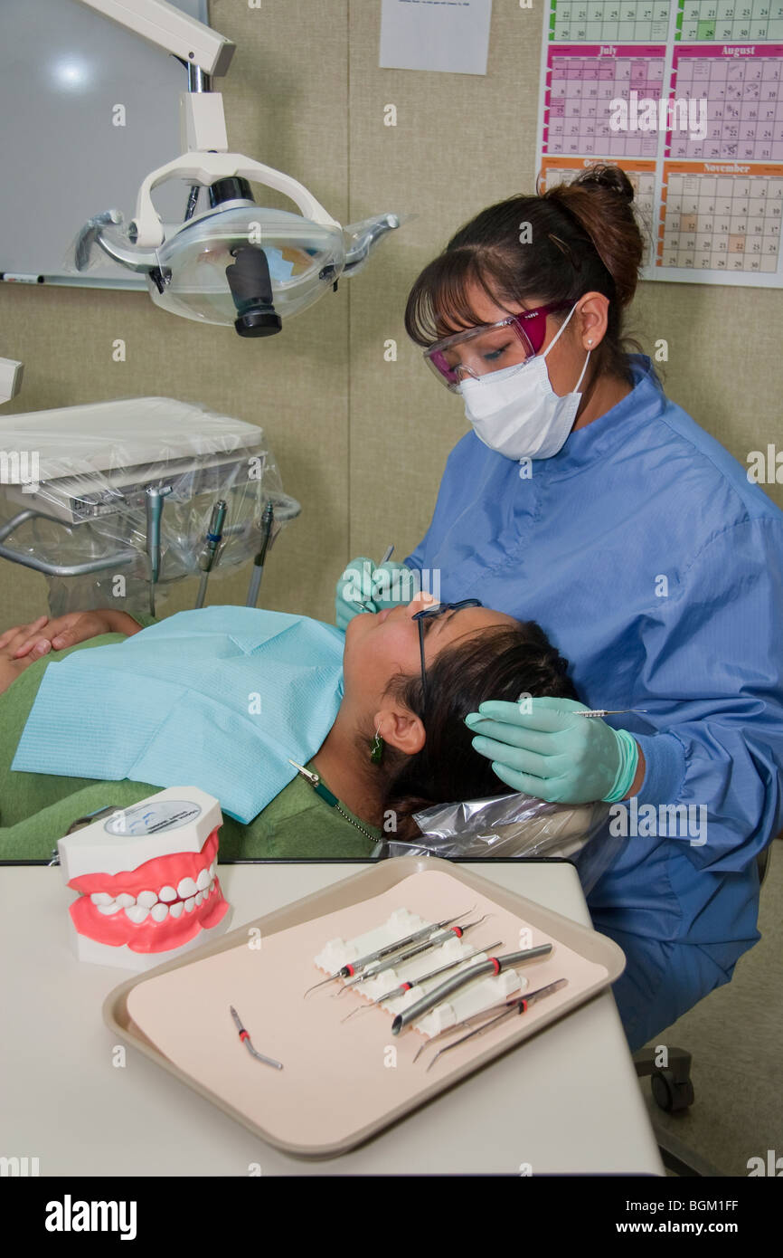 Il dentista nativo americano pulisce i denti di un paziente durante una visita alla clinica del dentista sulla riserva di Salish Kootenai in Montana Foto Stock