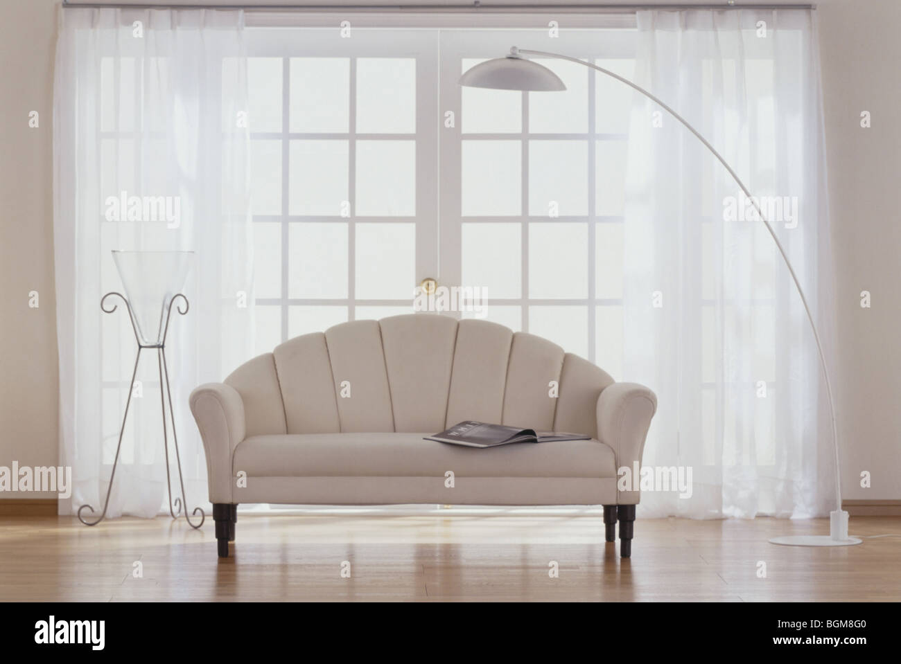 Il beige divano in camera con porte in vetro Foto Stock