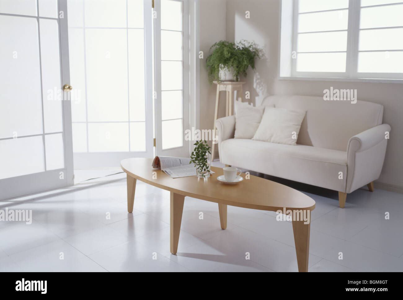 Divano e tavolo da caffè in camera con porte in vetro Foto Stock