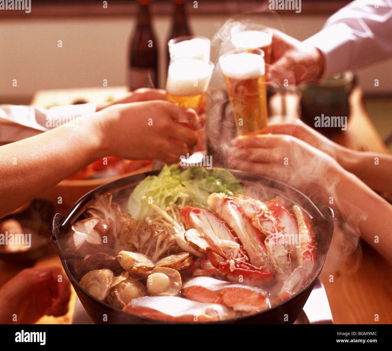La gente la tostatura con birra su piatto di frutti di mare Foto Stock