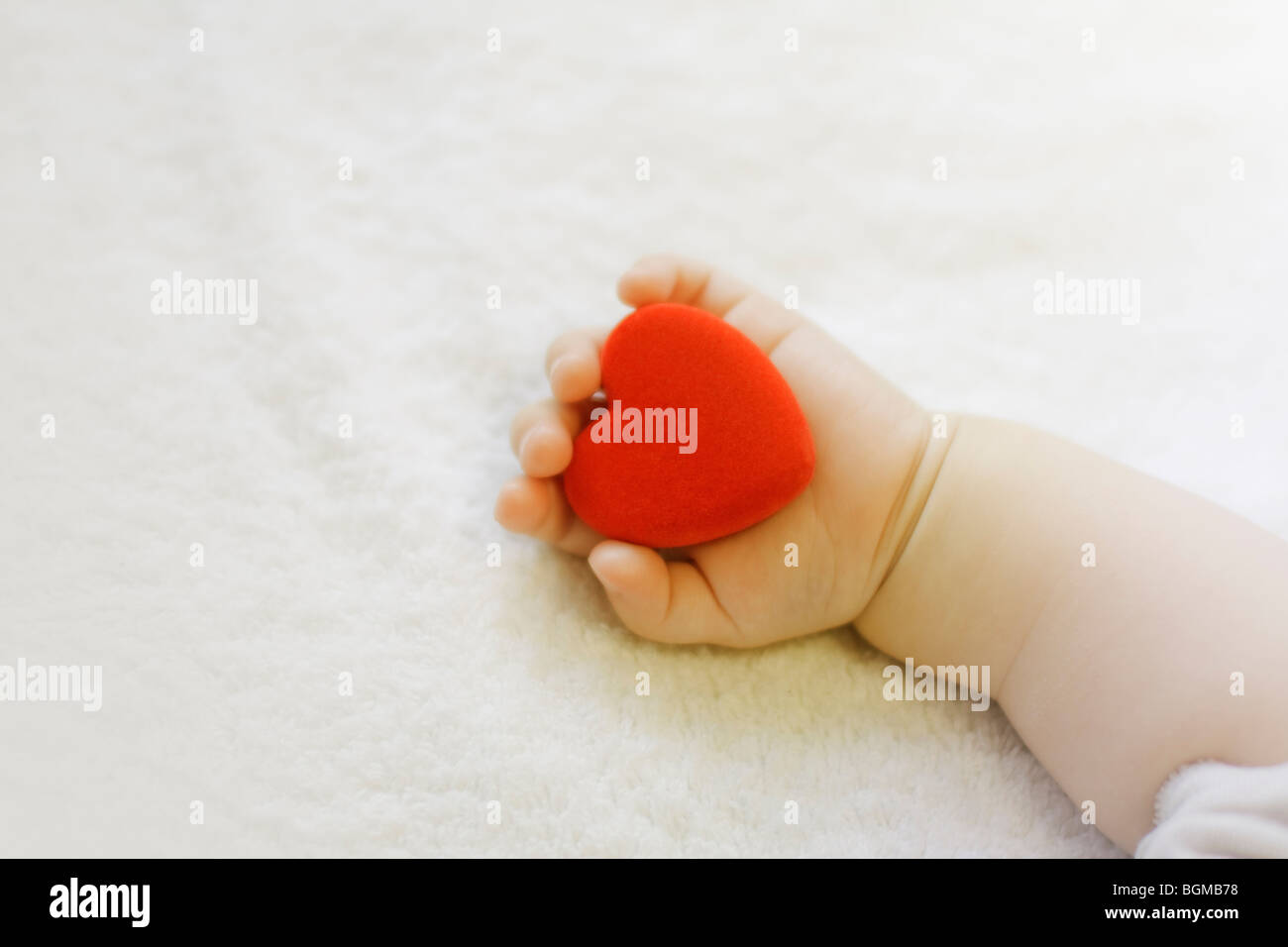 Baby azienda cuore rosso Foto Stock