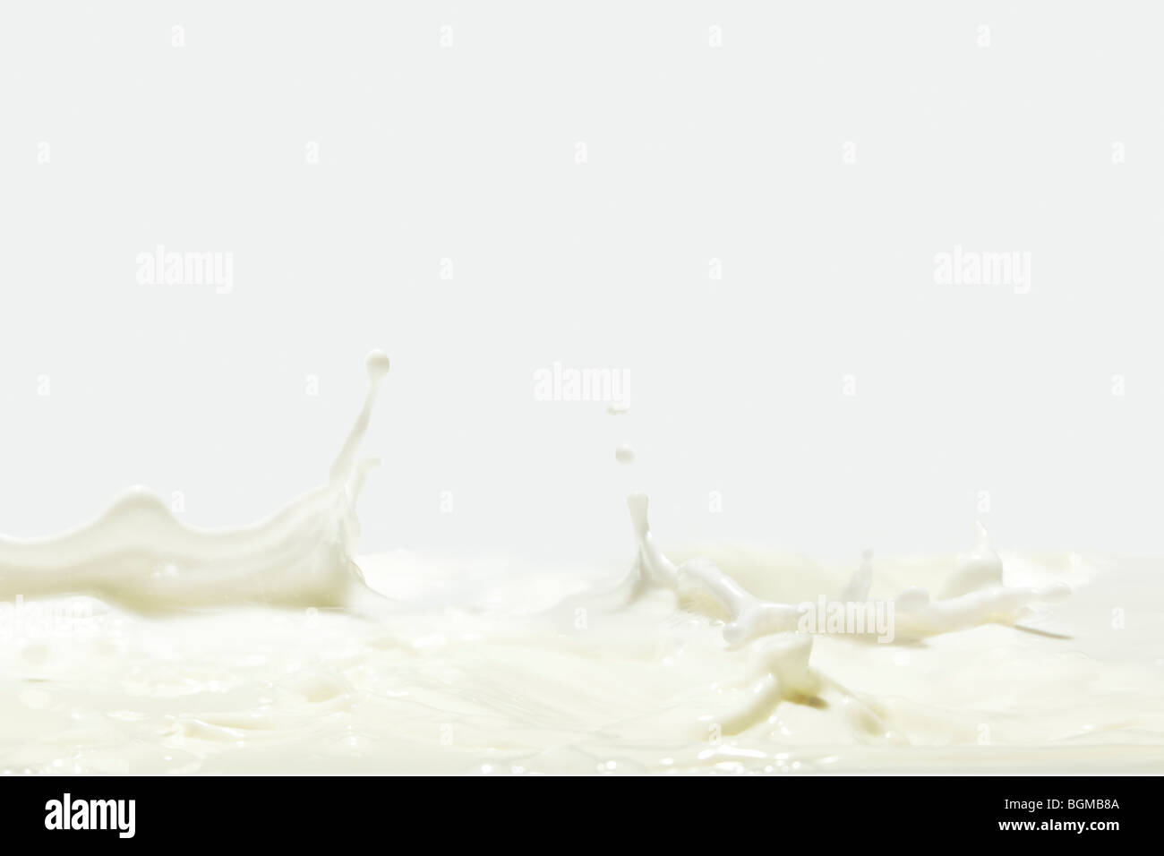 Gli spruzzi di latte su sfondo bianco Foto Stock