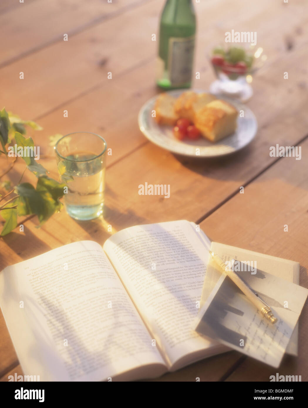 Un libro e un bicchiere di acqua su un tavolo di legno Foto Stock