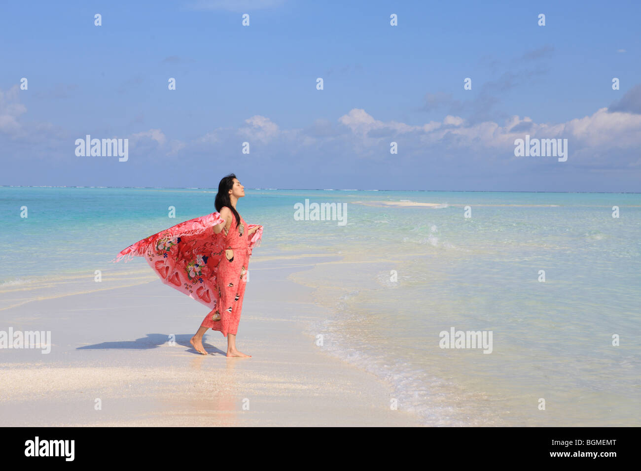 Donna godendo della brezza in spiaggia, alle Maldive Foto Stock