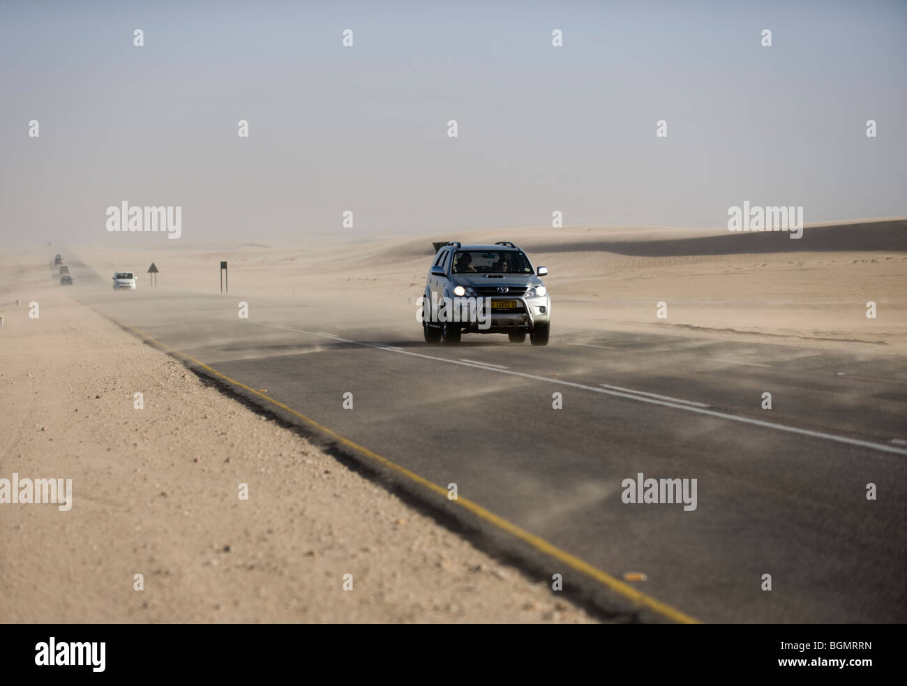 Guida lungo una strada che attraversa il deserto della Namibia Foto Stock