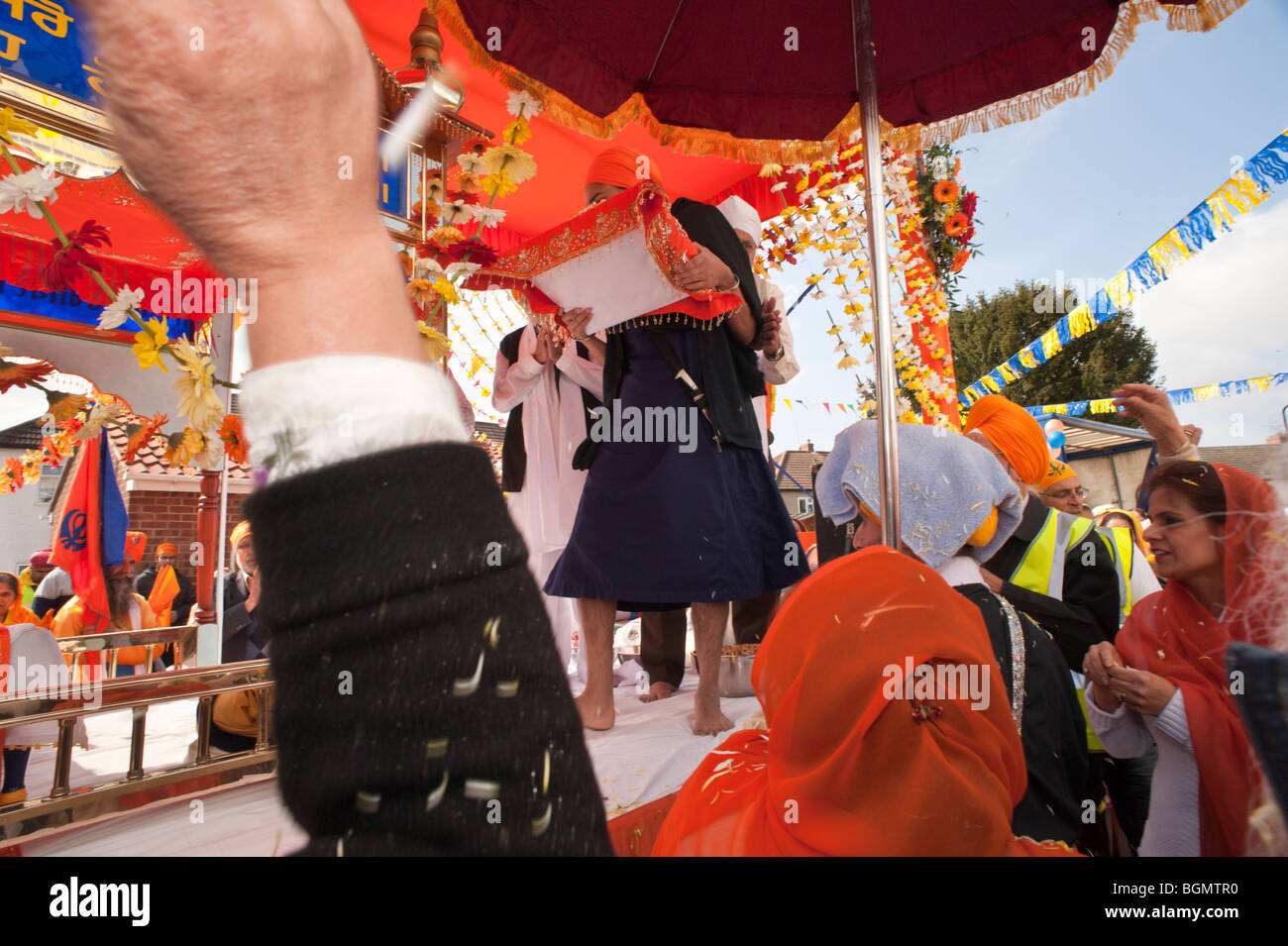 Il Guru Granth Sahib è sollevato al di sopra di un galleggiante per la processione Vaisakhi al di fuori del Gurdwara Slough Foto Stock