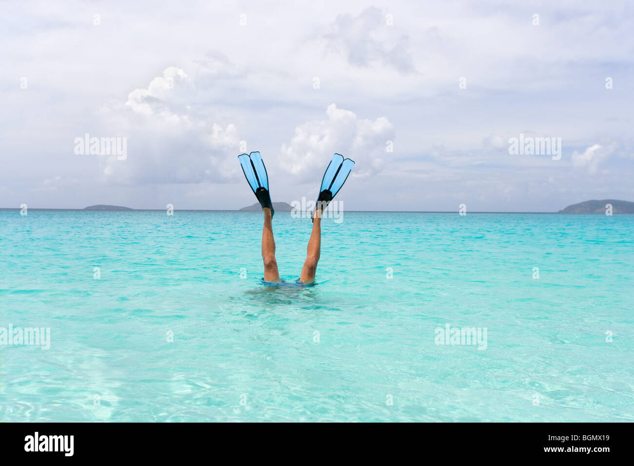 Diving snorkeler giù con snorkeling alette sporgono al di fuori dell'acqua Foto Stock